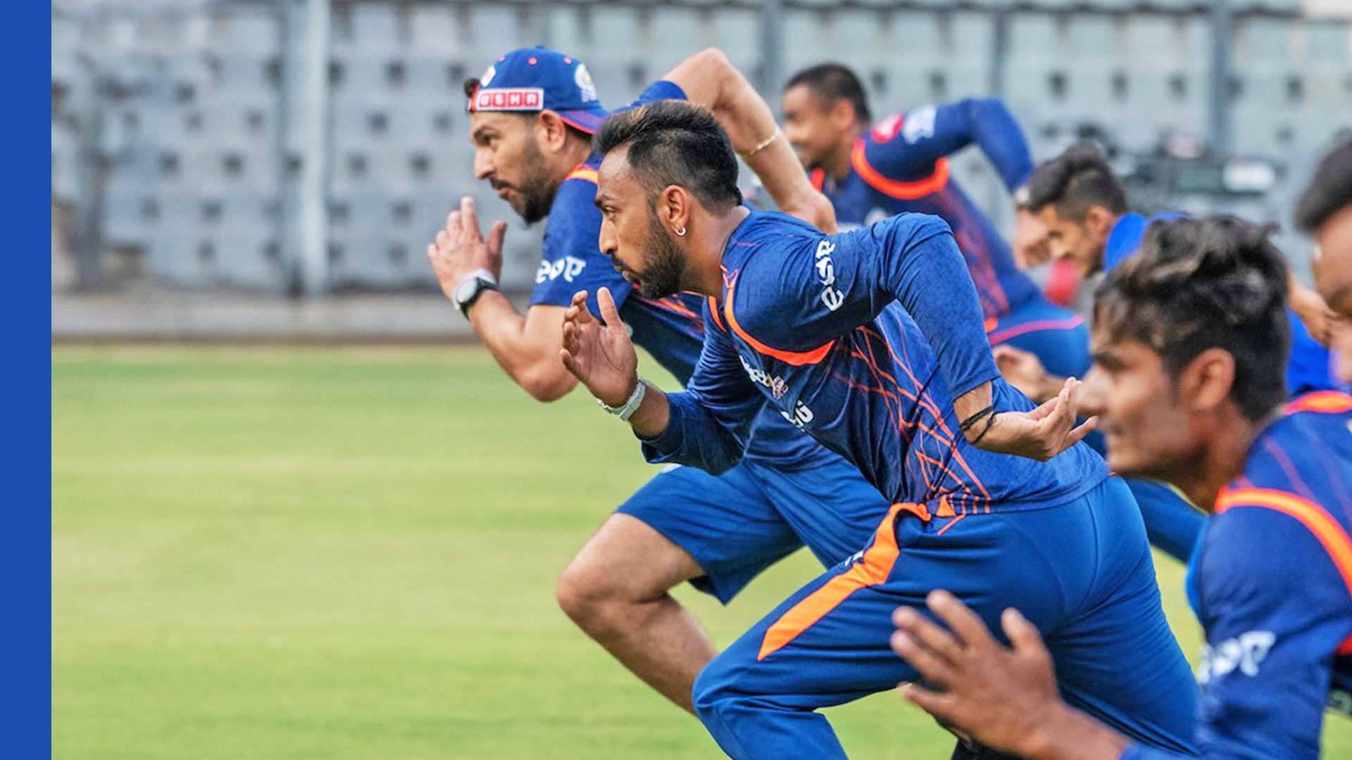 Delhi Capitals 桌布 壁紙 — 穿著藍色球衣的板球運動員在明亮的日光下訓練，在綠色場地上衝刺。