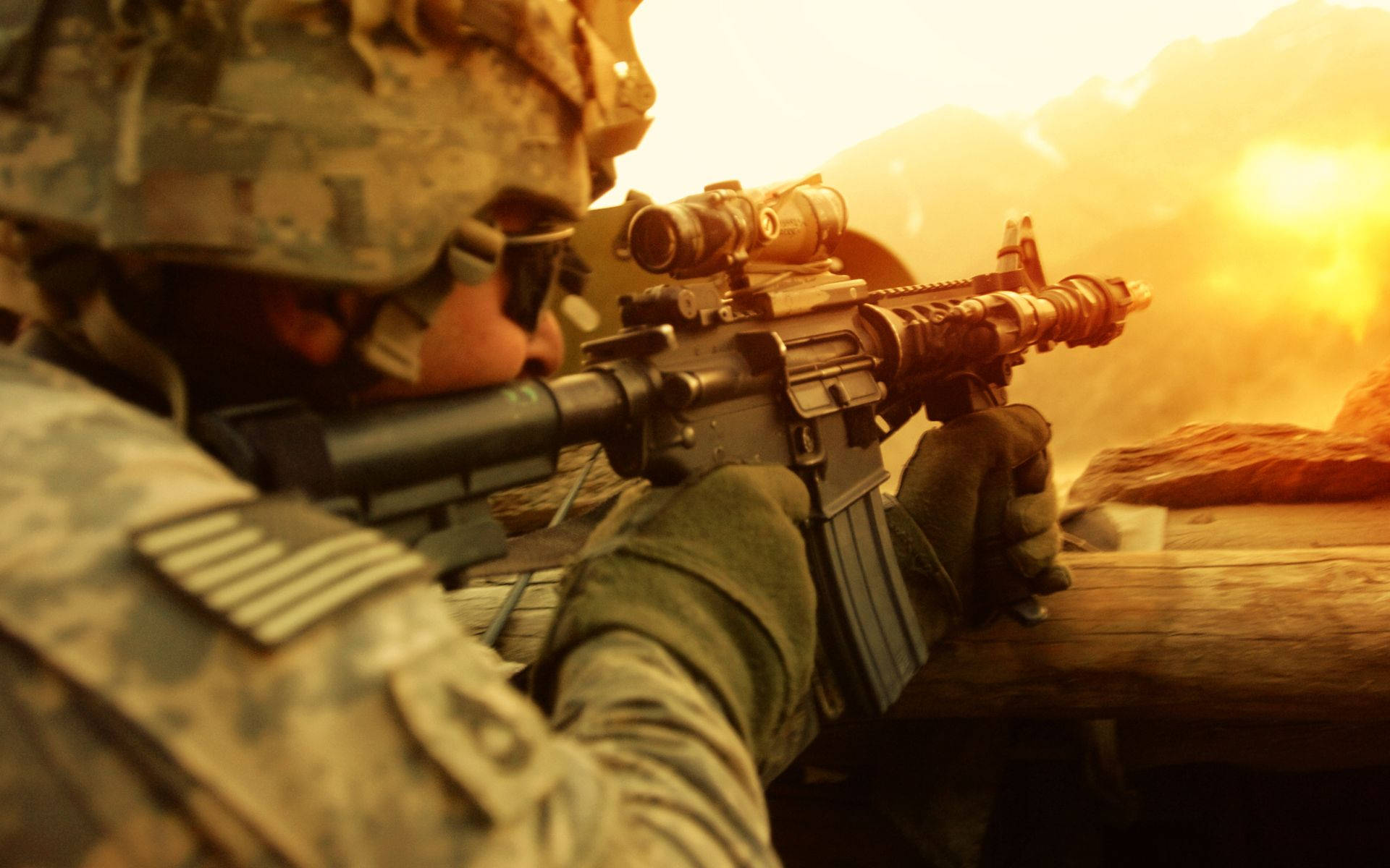 US 桌布 壁紙 — 穿著迷彩服的士兵透過瞄準鏡瞄準步槍，背景是煙霧和岩石地形的熾熱日落。