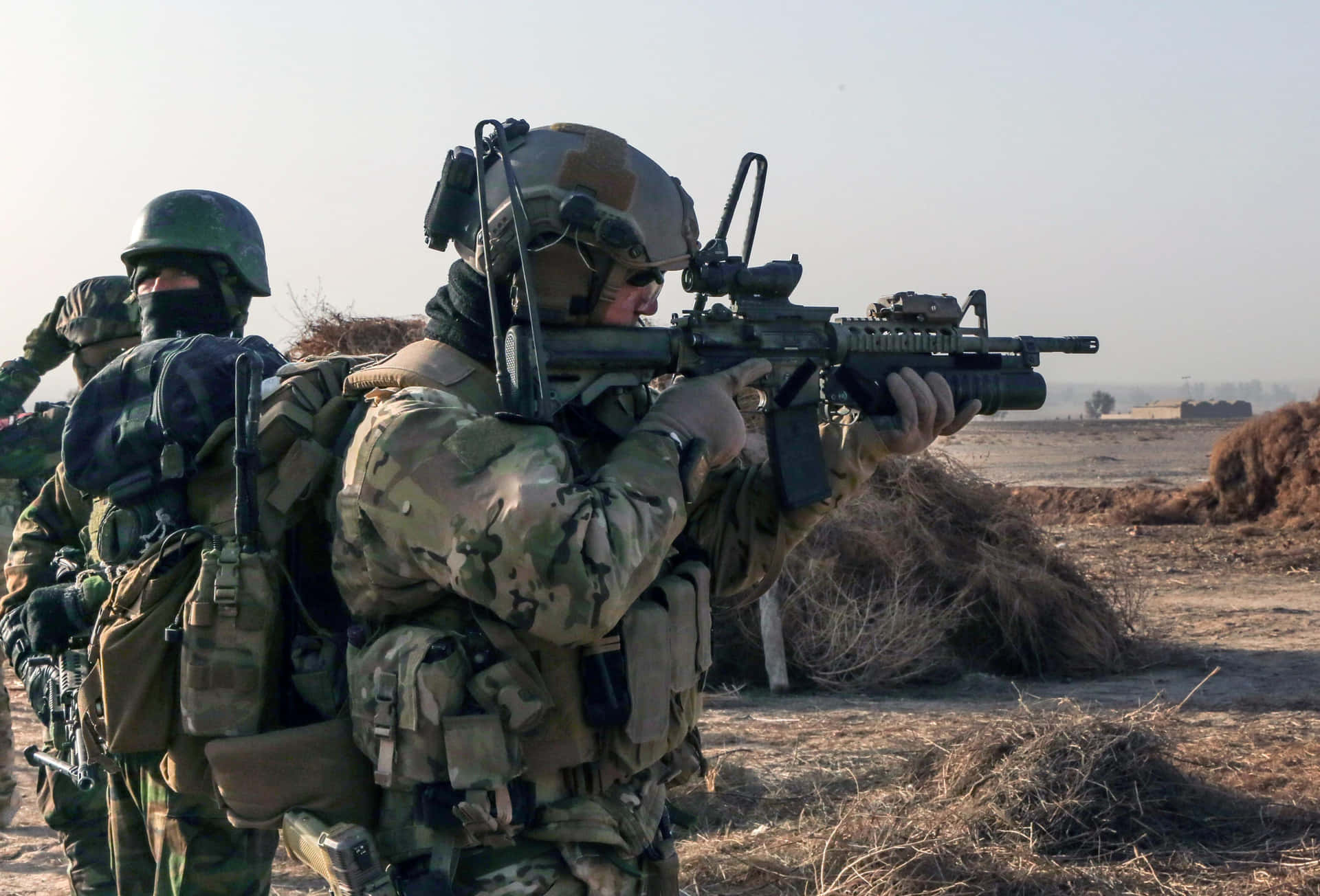 穿著戰鬥裝備的士兵在乾燥的田野中瞄準步槍。 — 軍隊 壁紙