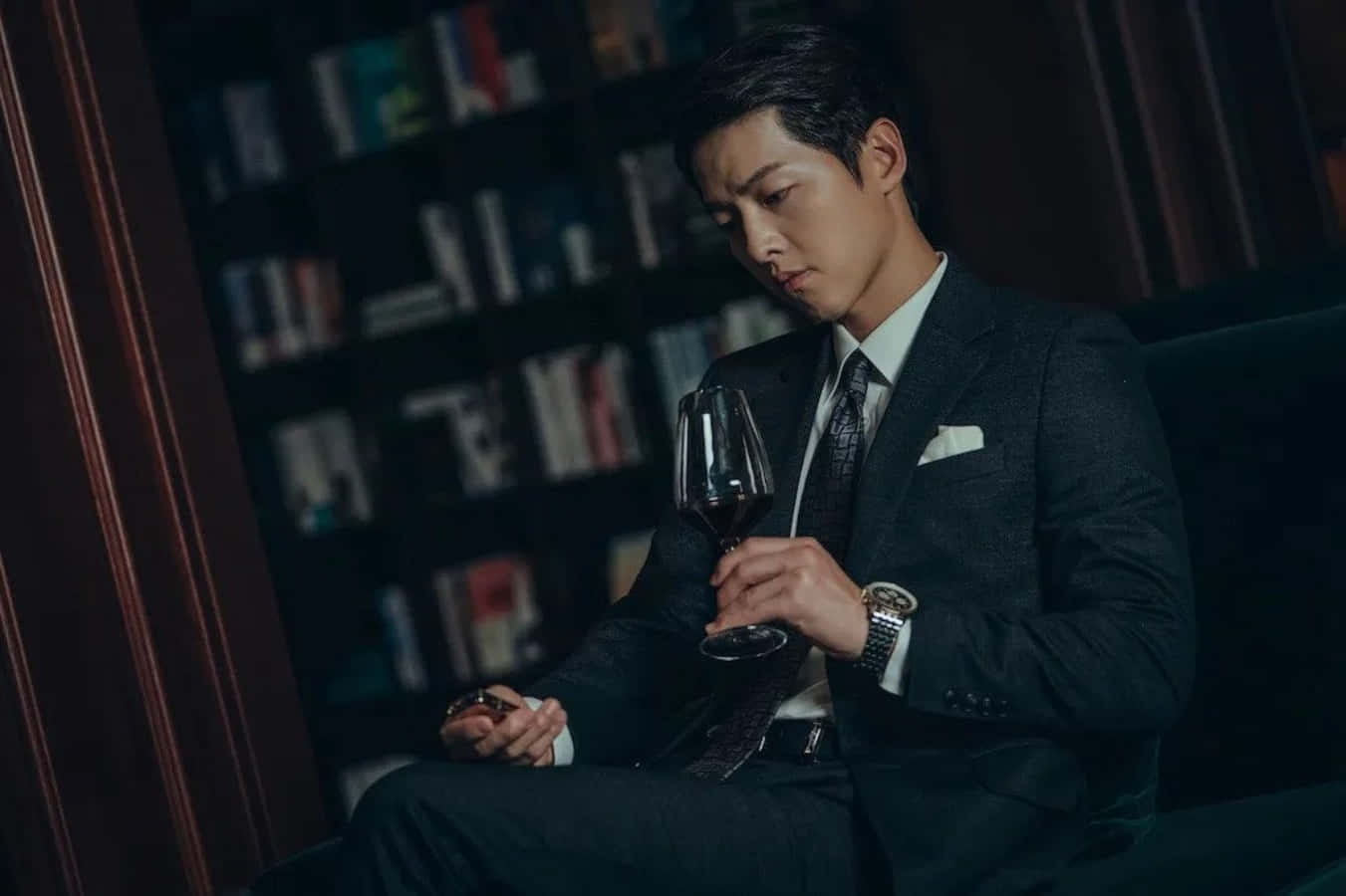 穿西装的男人坐在沙发上手持酒杯 壁紙