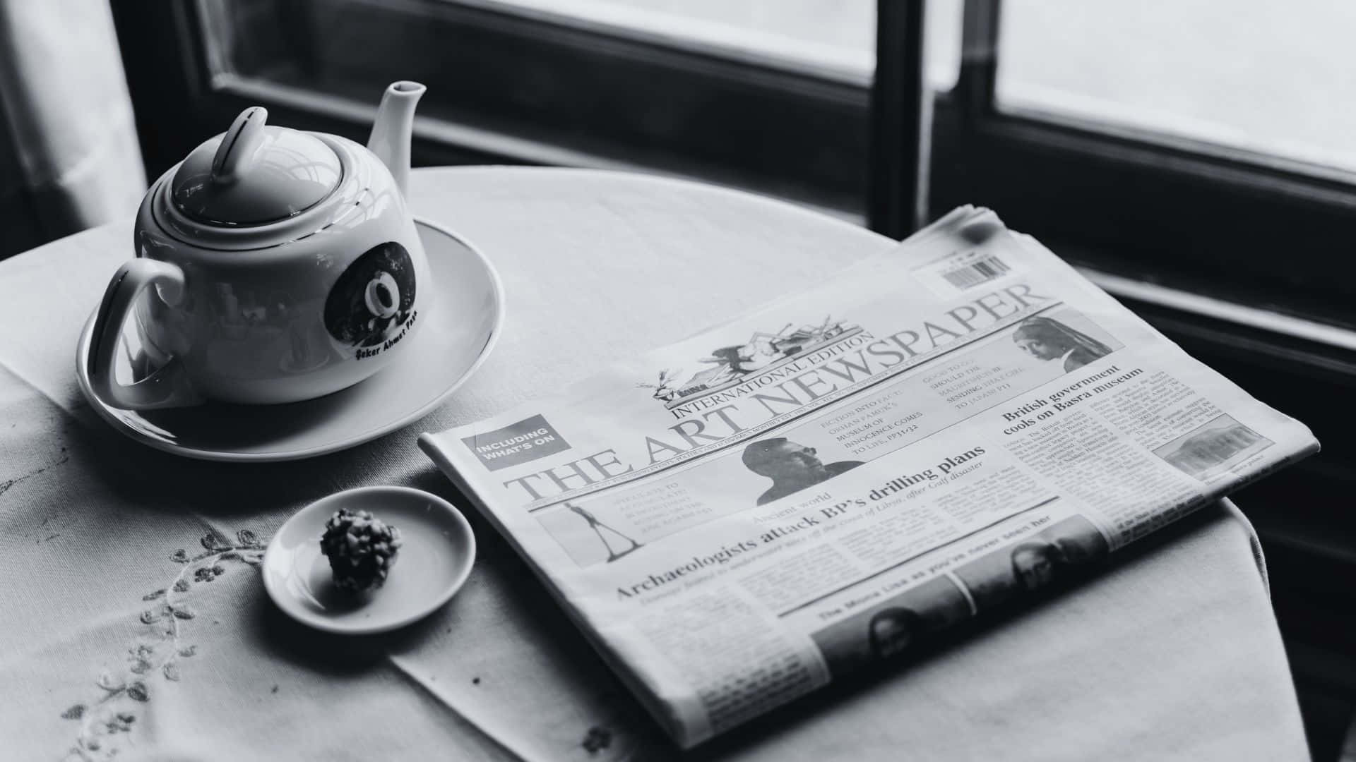 Black And White Newspaper 桌布 壁紙 — 窗邊桌上的茶壺、報紙和甜點的單色靜物照