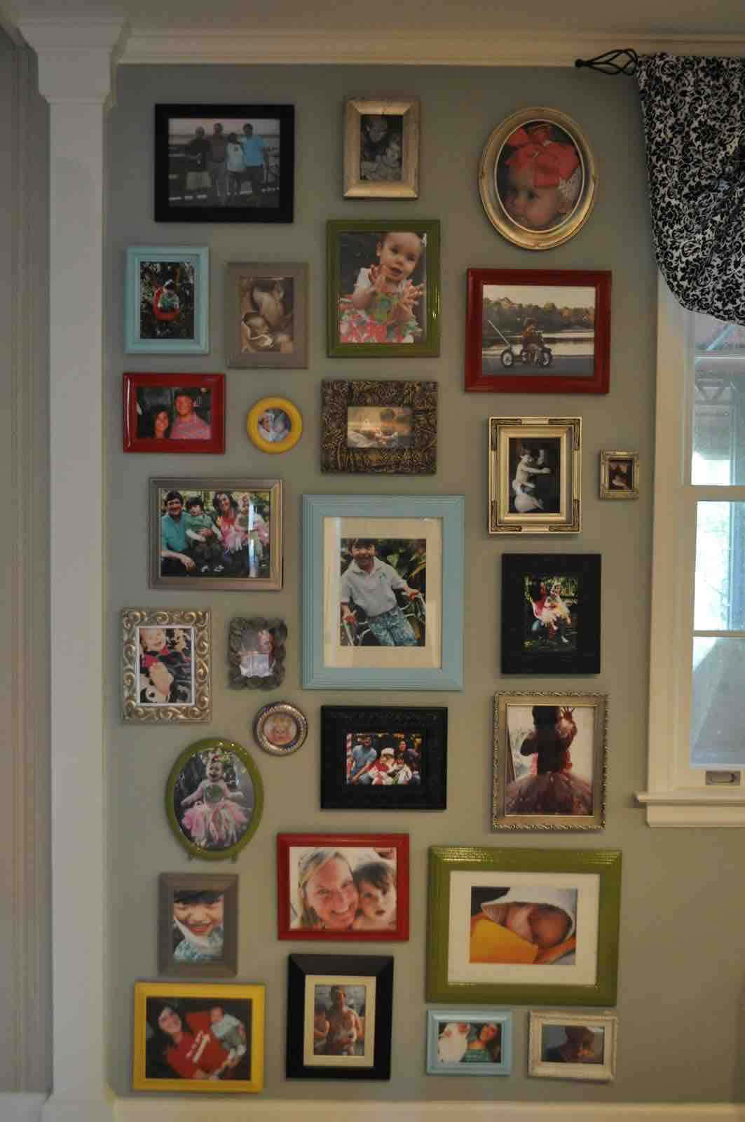 Wall Collage 桌布 壁紙 — 窗邊附近的牆上掛滿了各種彩色相框的家庭照片，感覺很溫馨。