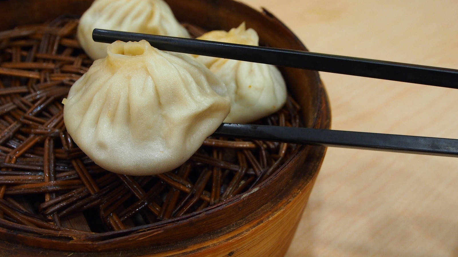 steam 桌布 壁紙 — 竹蒸籠中蒸氣騰騰的點心，配上黑色筷子準備上菜。