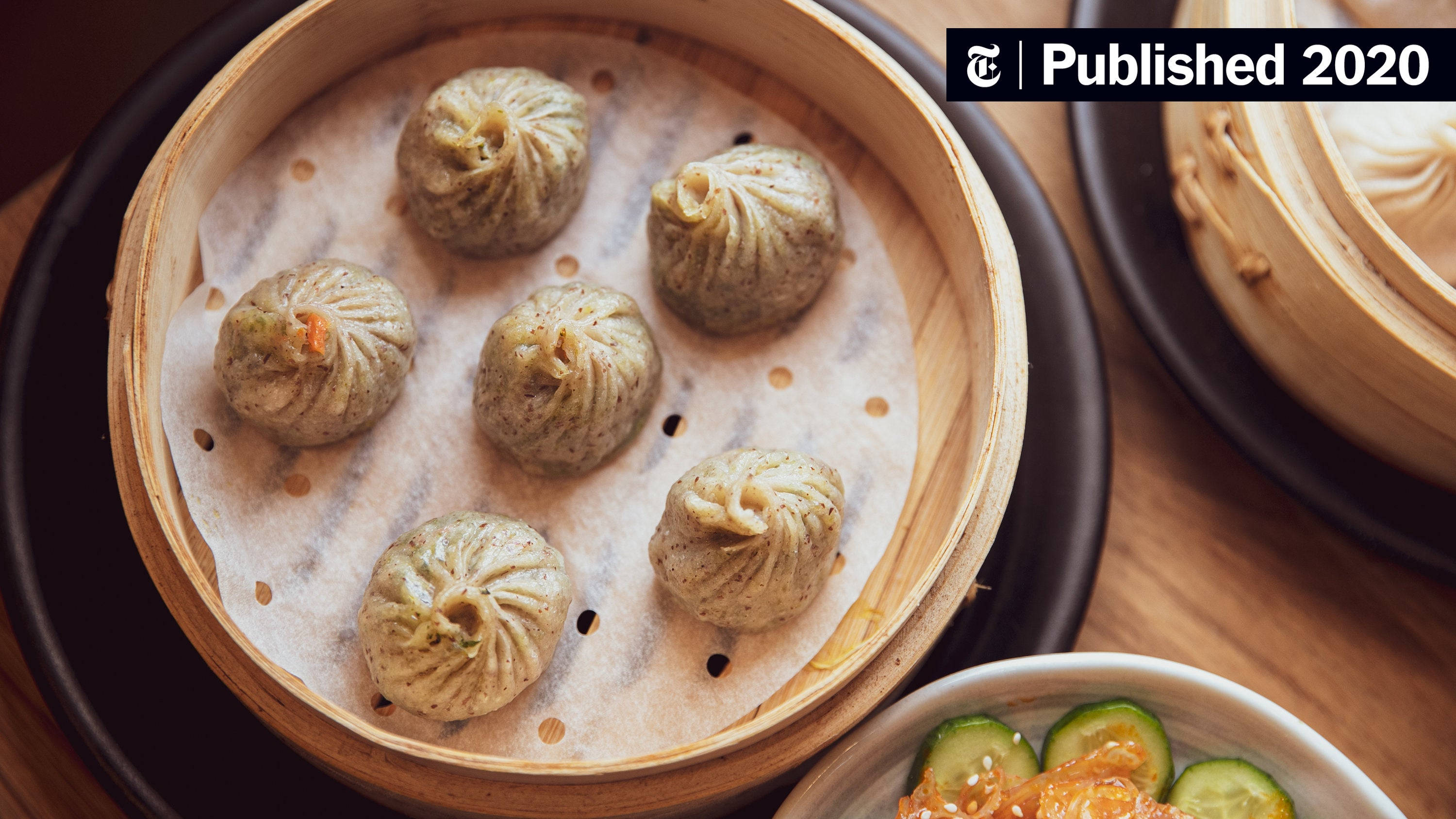steam 桌布 壁紙 — 竹蒸籠裡冒著蒸氣的餃子，旁邊有醃菜，放在木桌上。