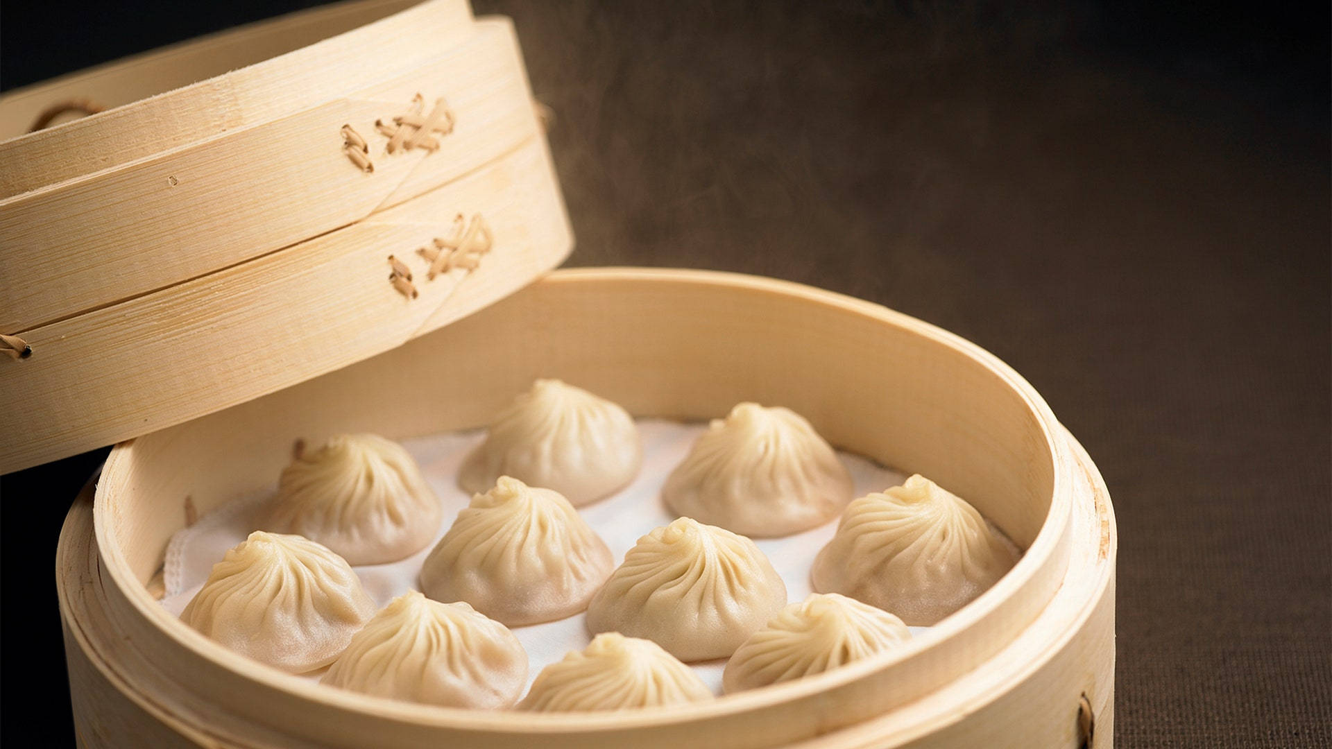 竹蒸籠裡的蒸餃，可見蒸氣裊裊。 — 食物動圖 壁紙