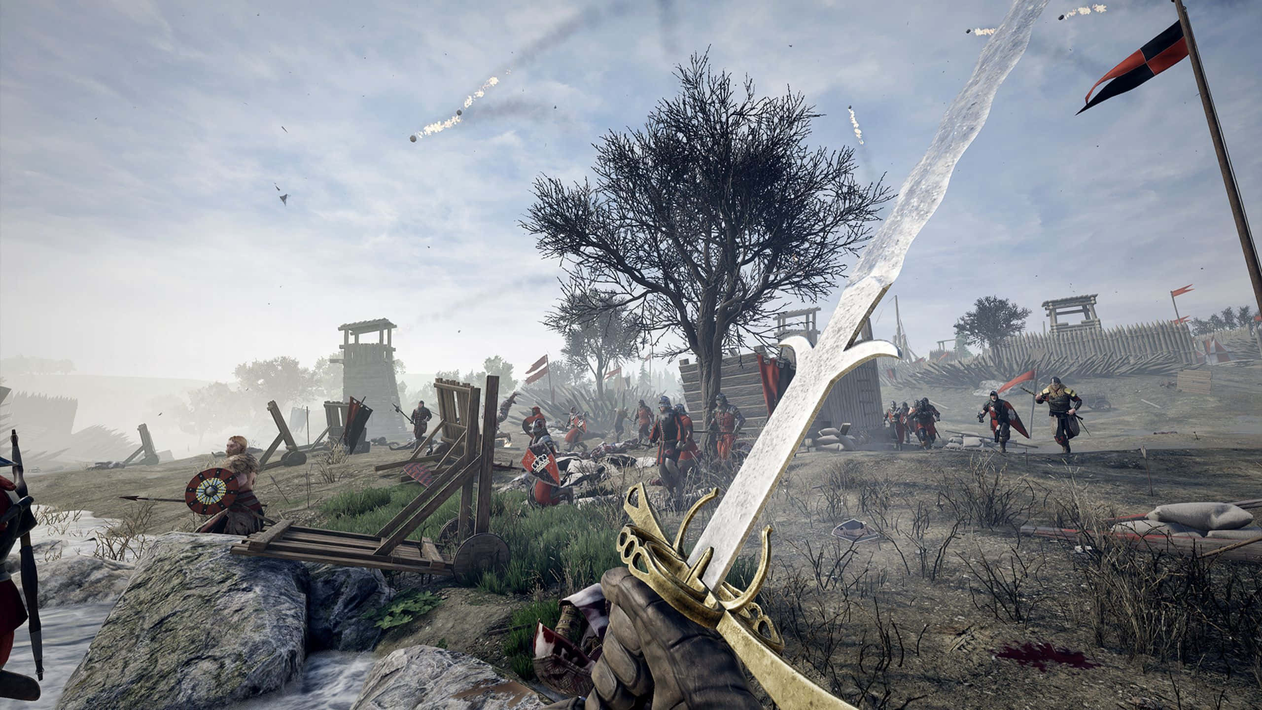 sword 桌布 壁紙 — 第一人稱視角，一把劍在混亂的中世紀戰場上拔出，士兵們在木製路障和一棵光禿禿的樹附近戰鬥。