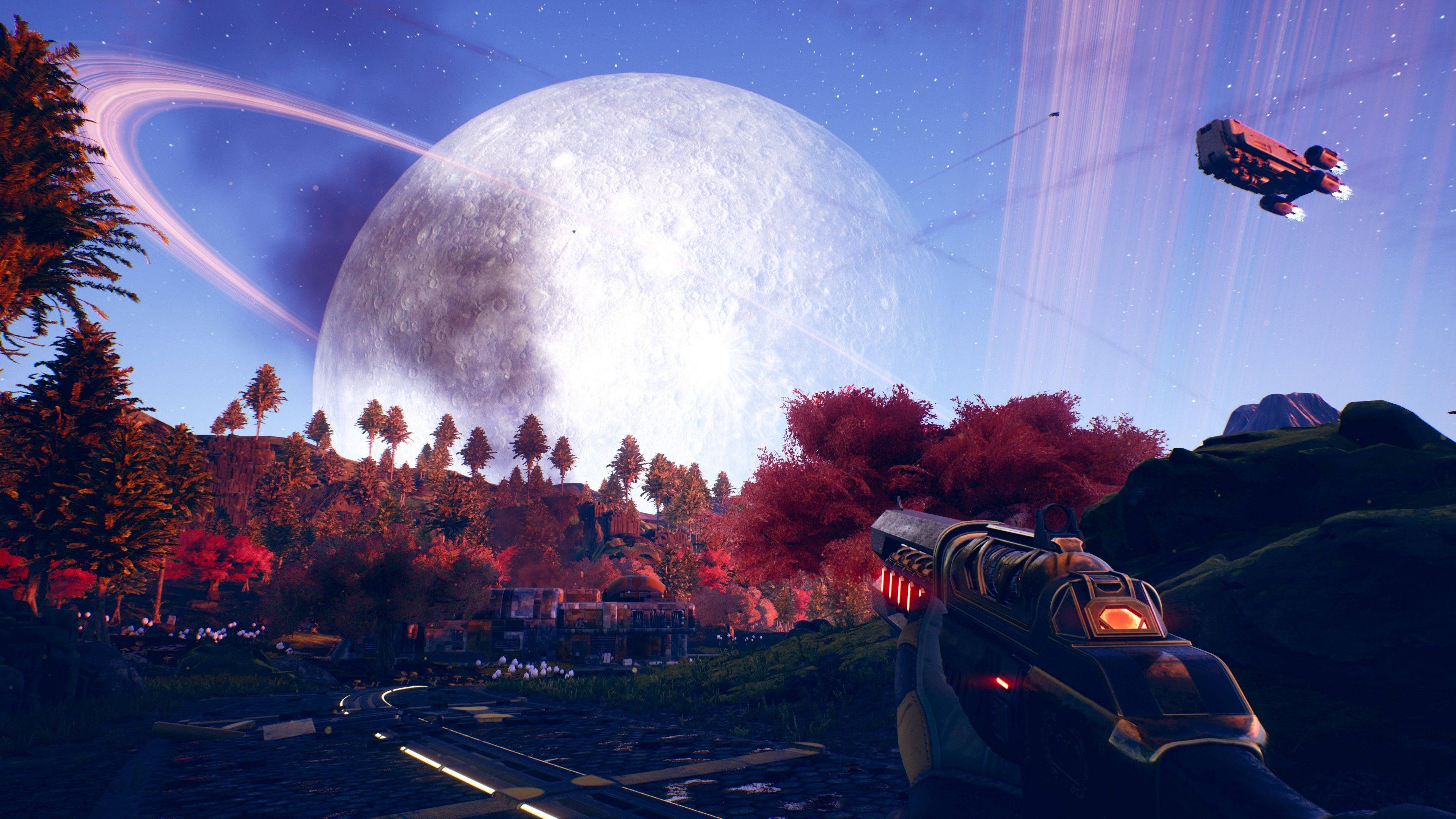 The Outer Worlds 桌布 壁紙 — 第一人稱視角，一把未來武器瞄準一艘遙遠的太空船，飛過一個巨大的環狀衛星，下方是森林密布的外星景觀。