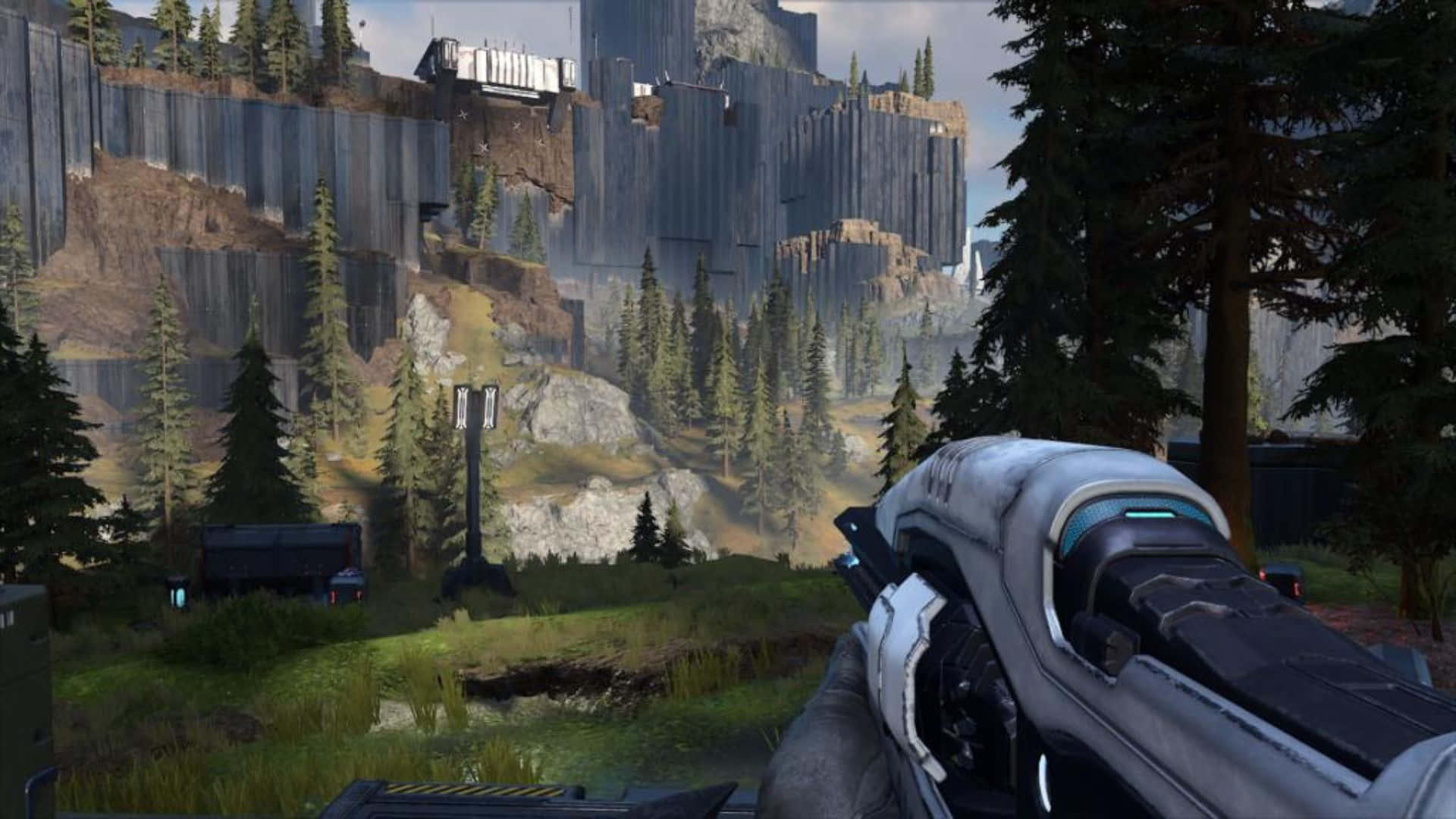 Plasma Rifle 桌布 壁紙 — 第一人稱視角，一把未來武器瞄準森林覆蓋的山谷中一座高聳的金屬結構。