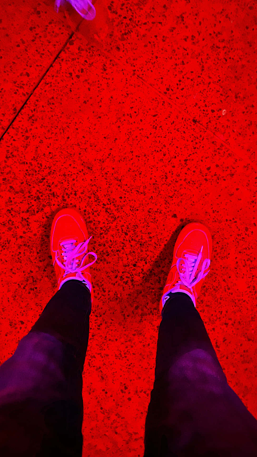 Aesthetic Red 桌布 壁紙 — 第一人稱視角：在強烈紅光下，鮮紅色斑點地板上的螢光粉紅色運動鞋。