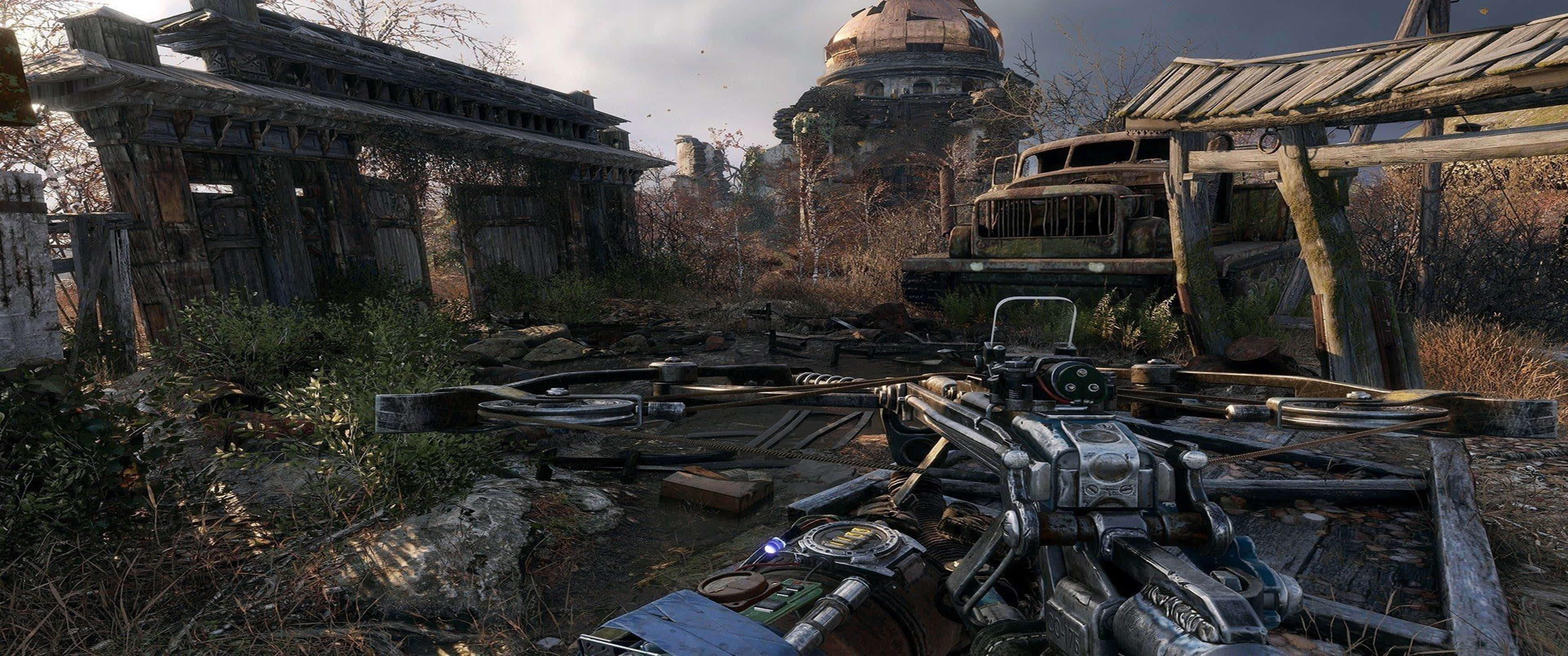 3440x1440p Metro Exodus 桌布 壁紙 — 第一人稱視角，展示一件未來武器，身處一個破敗、雜草叢生的末日後定居點，遠處有破舊建築和圓頂結構。