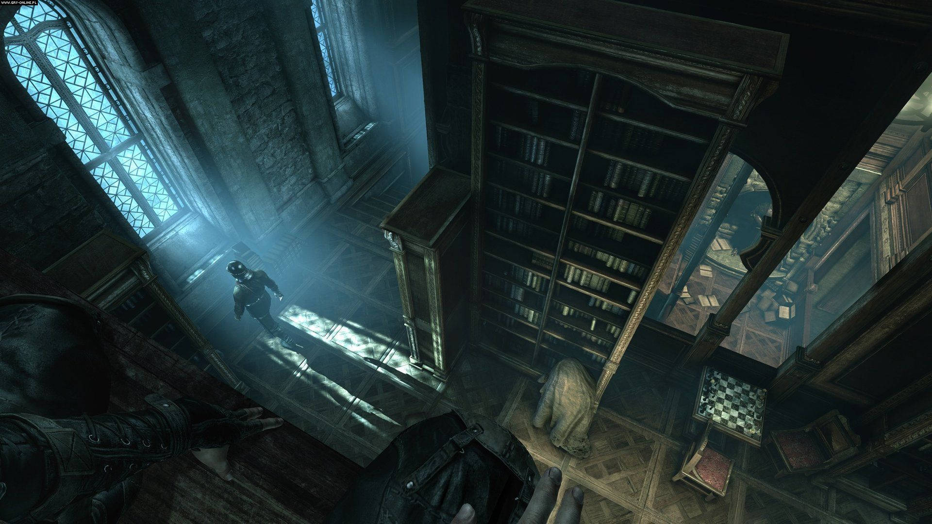 Thief 桌布 壁紙 — 第一人稱視角，角色在昏暗的哥德式圖書館中穿梭，周圍是高聳的書架和投射出藍光的彩繪玻璃窗。