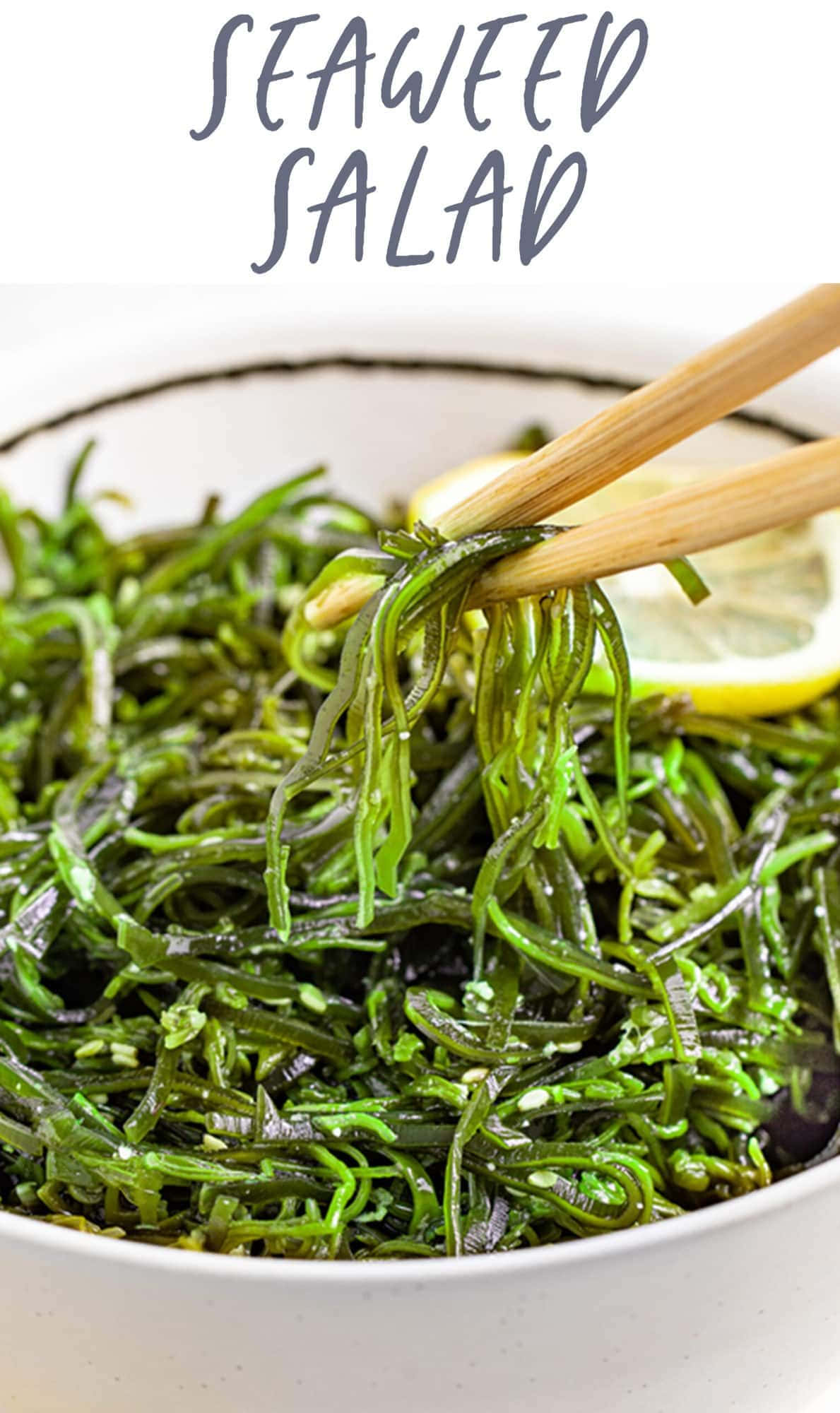 Seaweed 桌布 壁紙 — 筷子從白色碗中夾起閃亮綠色海藻沙拉，配以檸檬角裝飾的特寫。