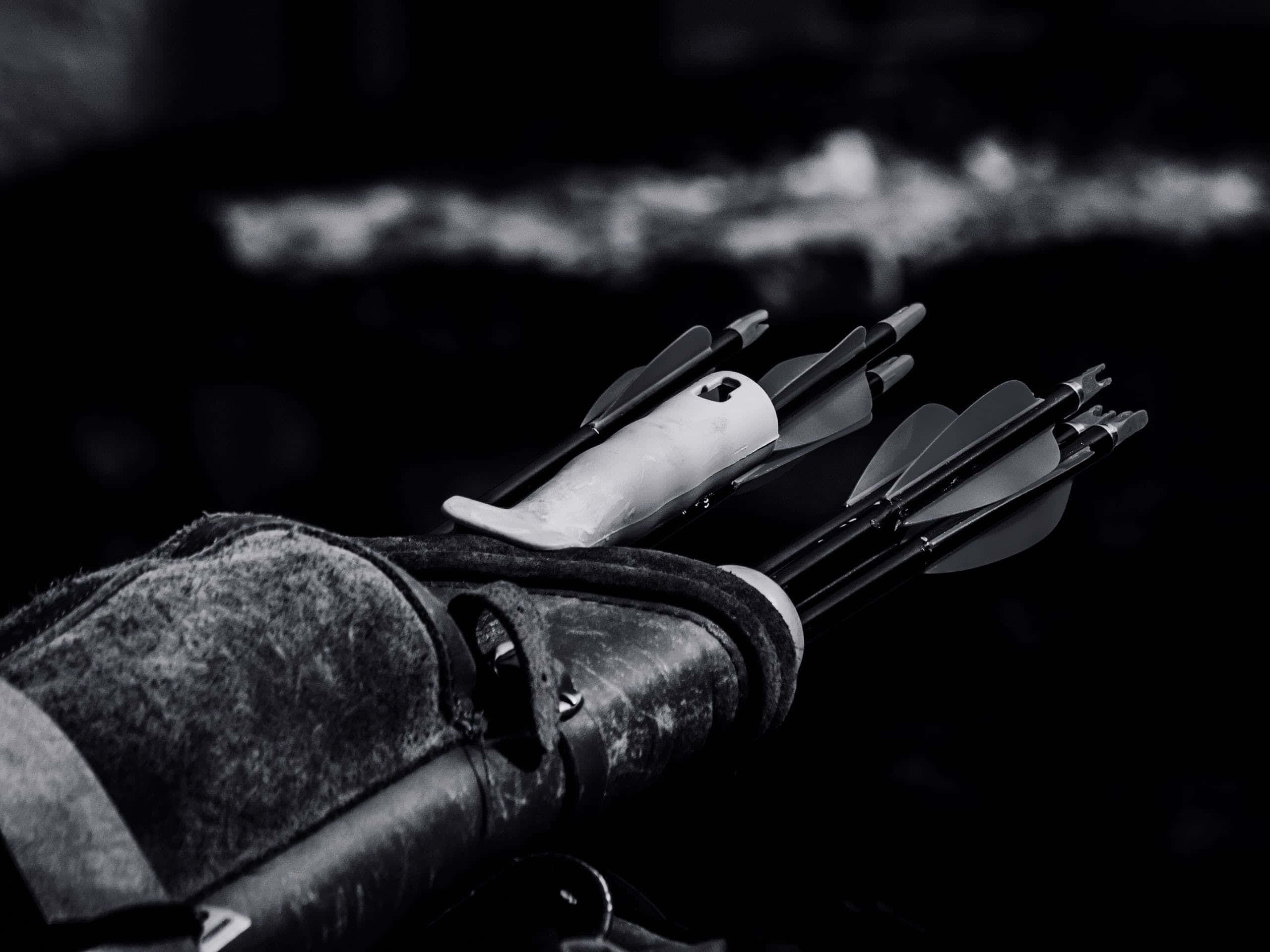 Archery 桌布 壁紙 — 箭袋中箭矢的單色特寫，背景為模糊的暗色調，帶有柔和煙霧般的高光。