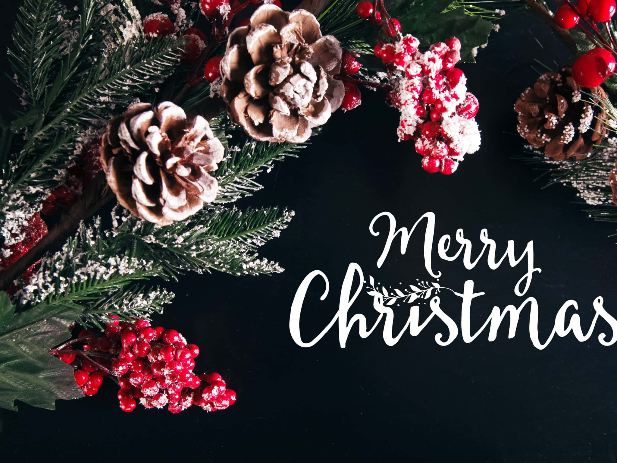 Christmas Eve 桌布 壁紙 — 節日聖誕花環，飾有松果、紅莓和霜凍綠植，深色背景上帶有白色草書文字。