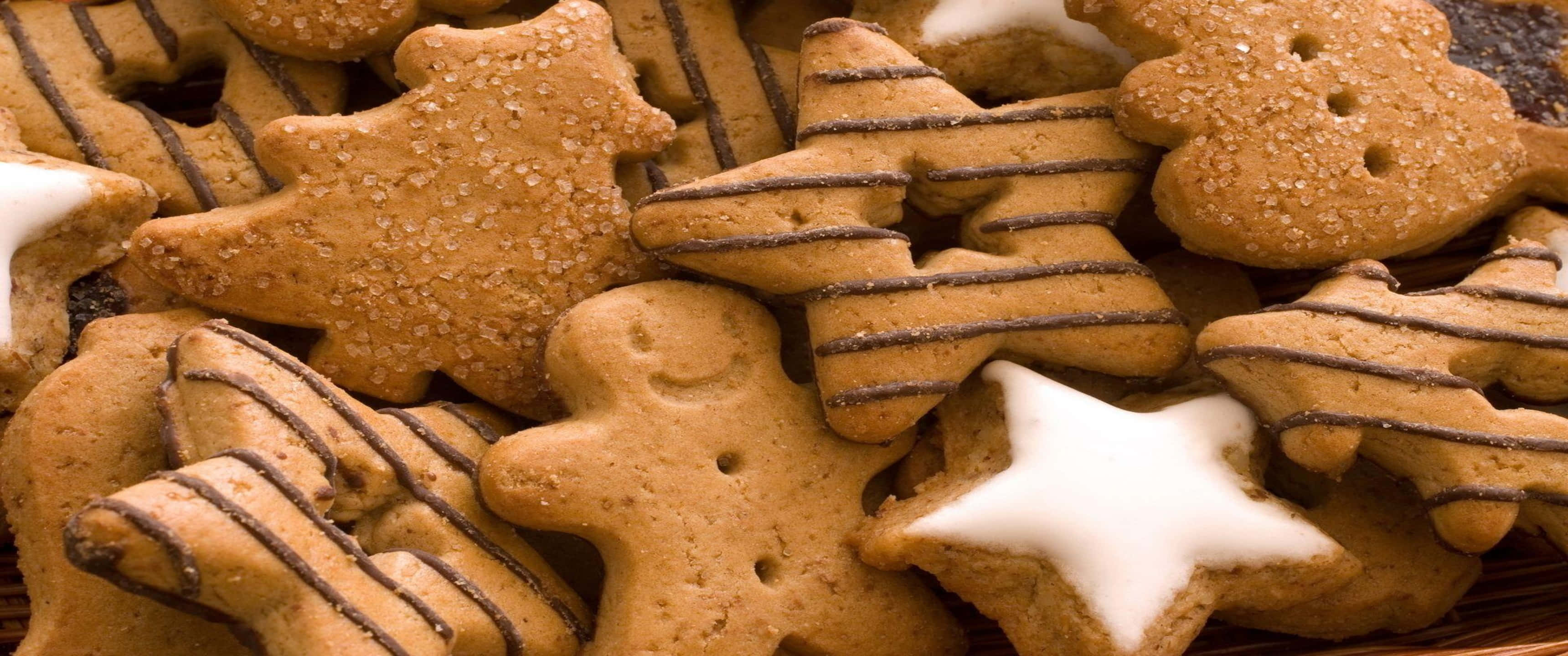 Cookies 桌布 壁紙 — 節日薑餅餅乾的特寫，造型為星星和小人，並以糖和巧克力醬裝飾。