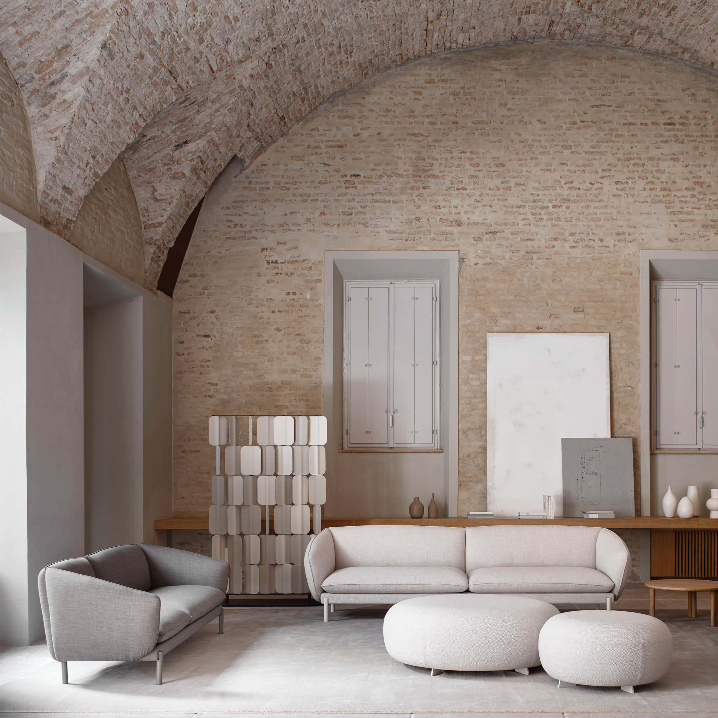 Living Room 桌布 壁紙 — 簡約客廳，設有裸露磚拱天花板和現代米色家具，柔和自然光線下。
