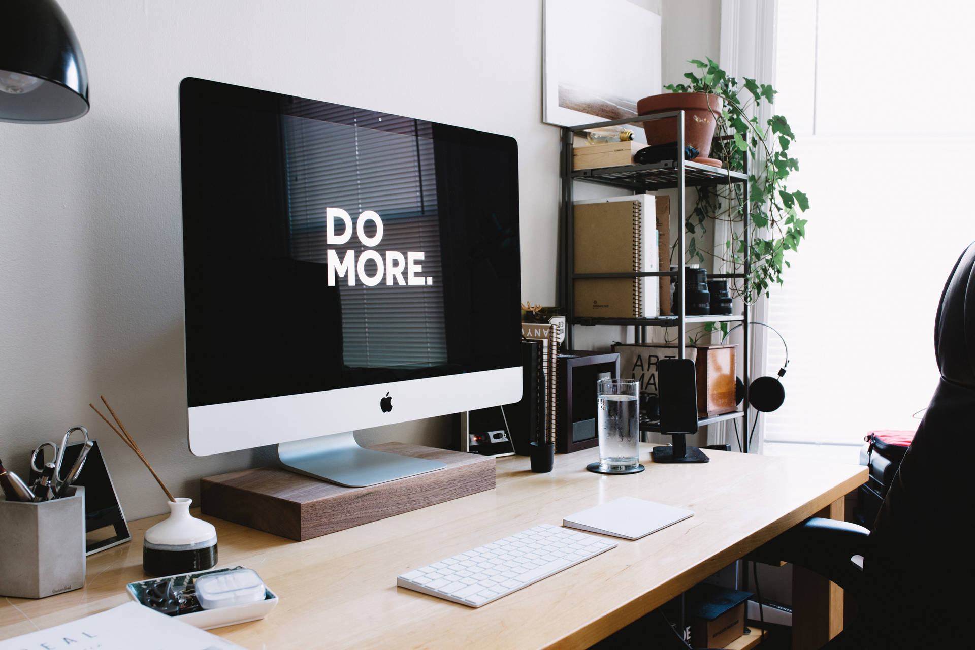簡約家居辦公室，iMac 顯示 'DO MORE' 和盆栽植物。 — 4K雙螢幕壁紙 壁紙
