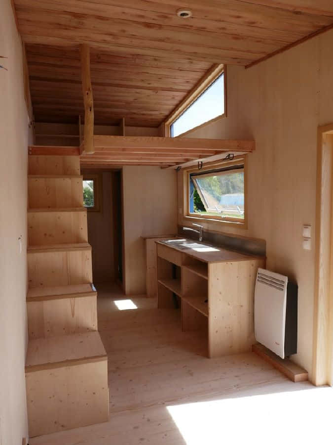 cabin 桌布 壁紙 — 簡約木屋內部，自然光透過窗戶照射進來，照亮閣樓樓梯和嵌入式水槽。