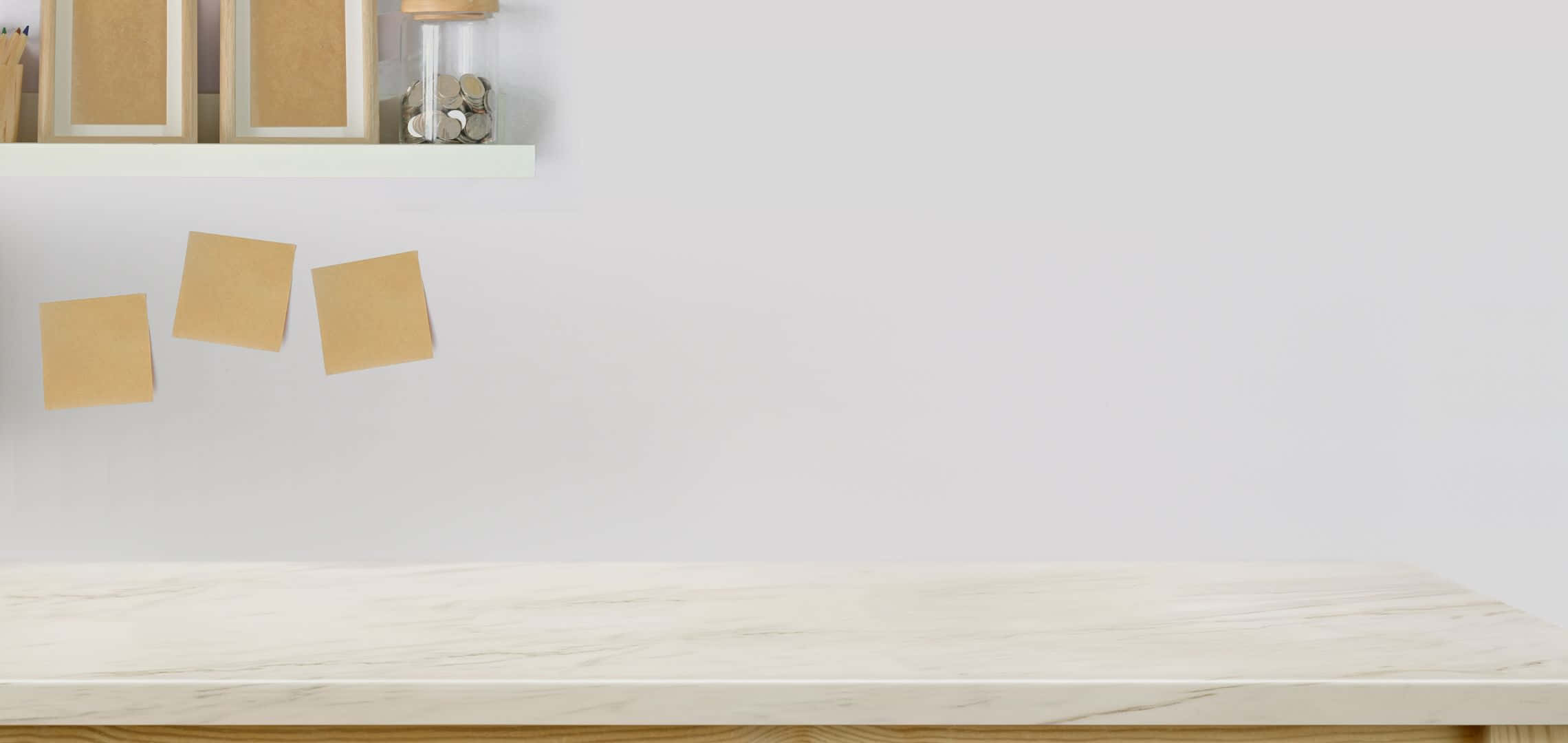 2280x1080 桌布 壁紙 — 簡約木桌，白色牆上貼有米色便利貼和帶框軟木板。