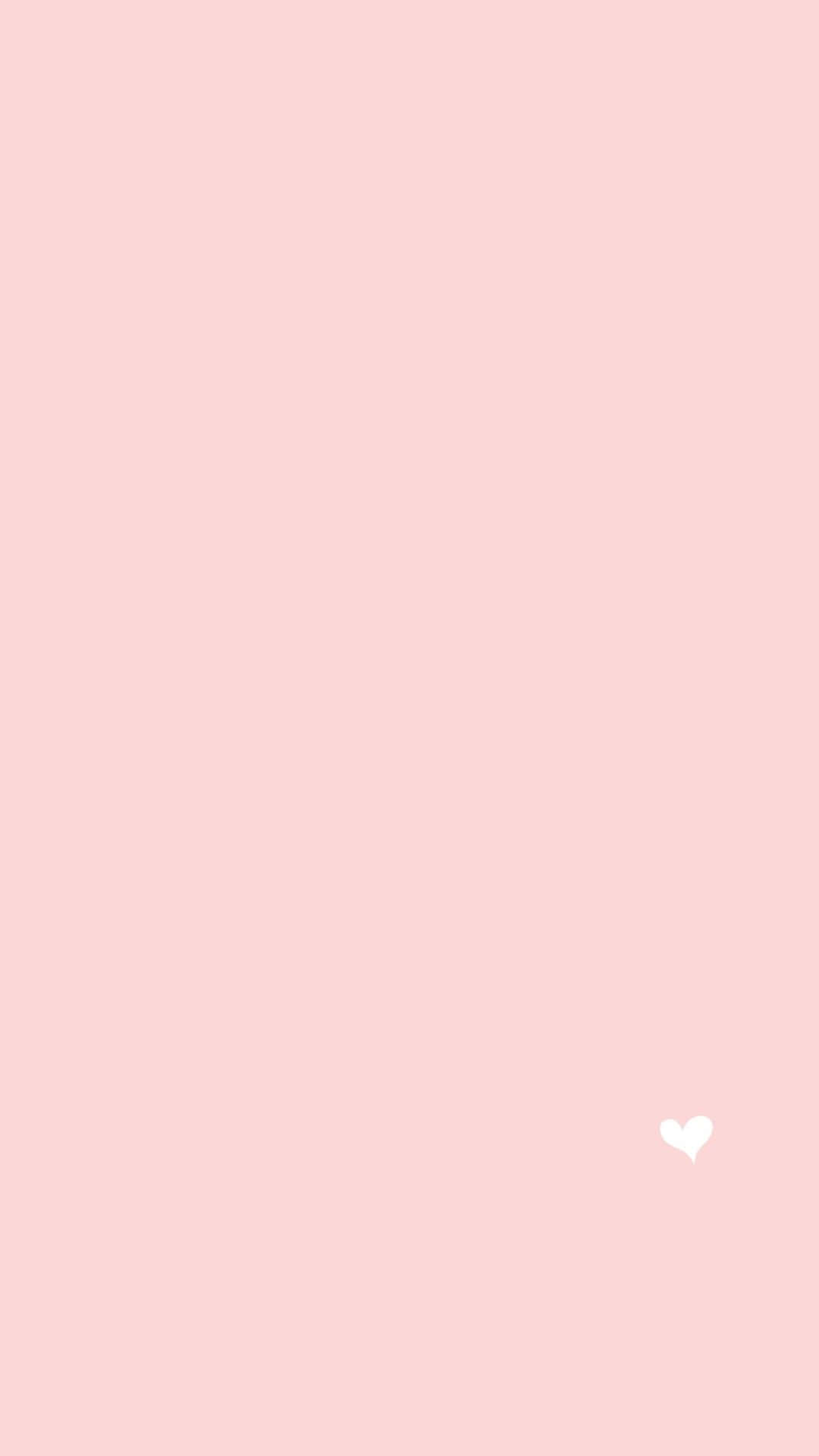 Minimalist Pink 桌布 壁紙 — 簡約淡粉紅色背景，右下角有一個細小的白色愛心。