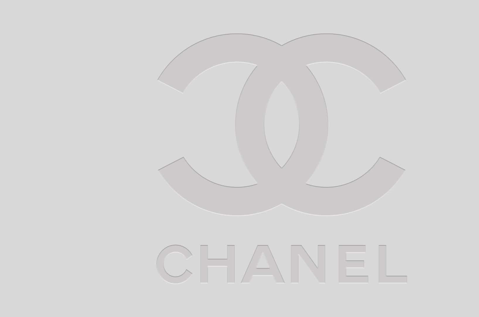 香奈兒標誌 桌布 壁紙 — 簡約灰色Chanel標誌，帶有互鎖CC標誌和品牌名稱，背景為純色。