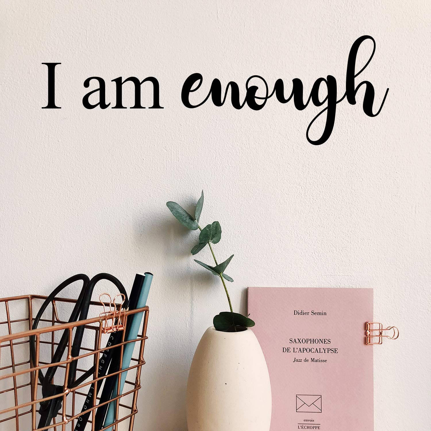 肯定語 桌布 壁紙 — 簡約牆飾，上面有「I am enough」文字，下方是尤加利葉花瓶和銅籃裡的粉紅色書本。