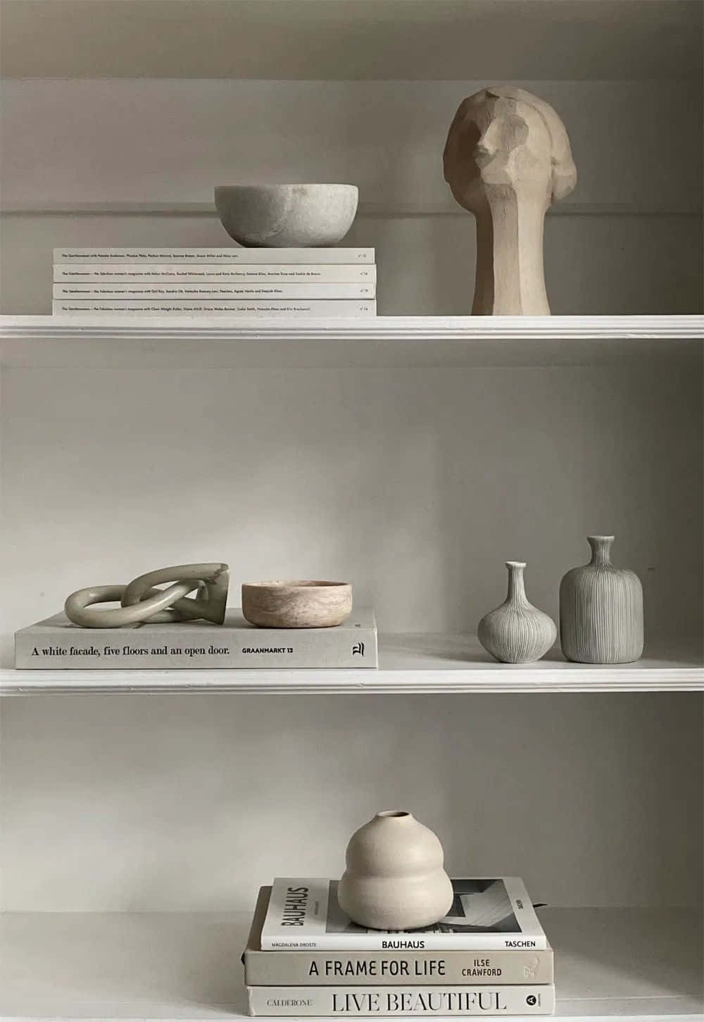 Minimalist Design 桌布 壁紙 — 簡約白色層架展示精選書籍和雕塑陶瓷，採用柔和中性色調。