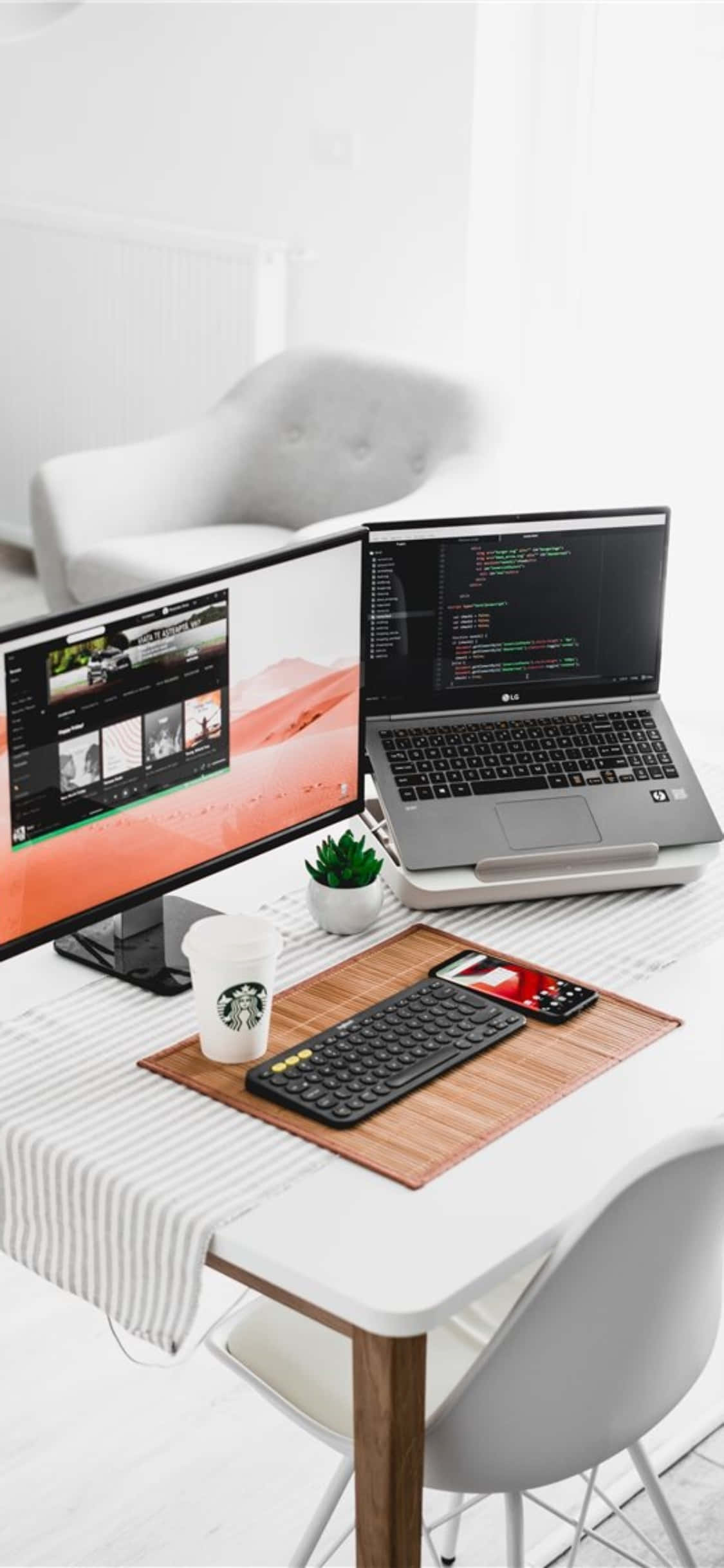 Desk 桌布 壁紙 — 簡約白色桌面設置，配備筆記型電腦編程和顯示影片編輯軟體的顯示器。