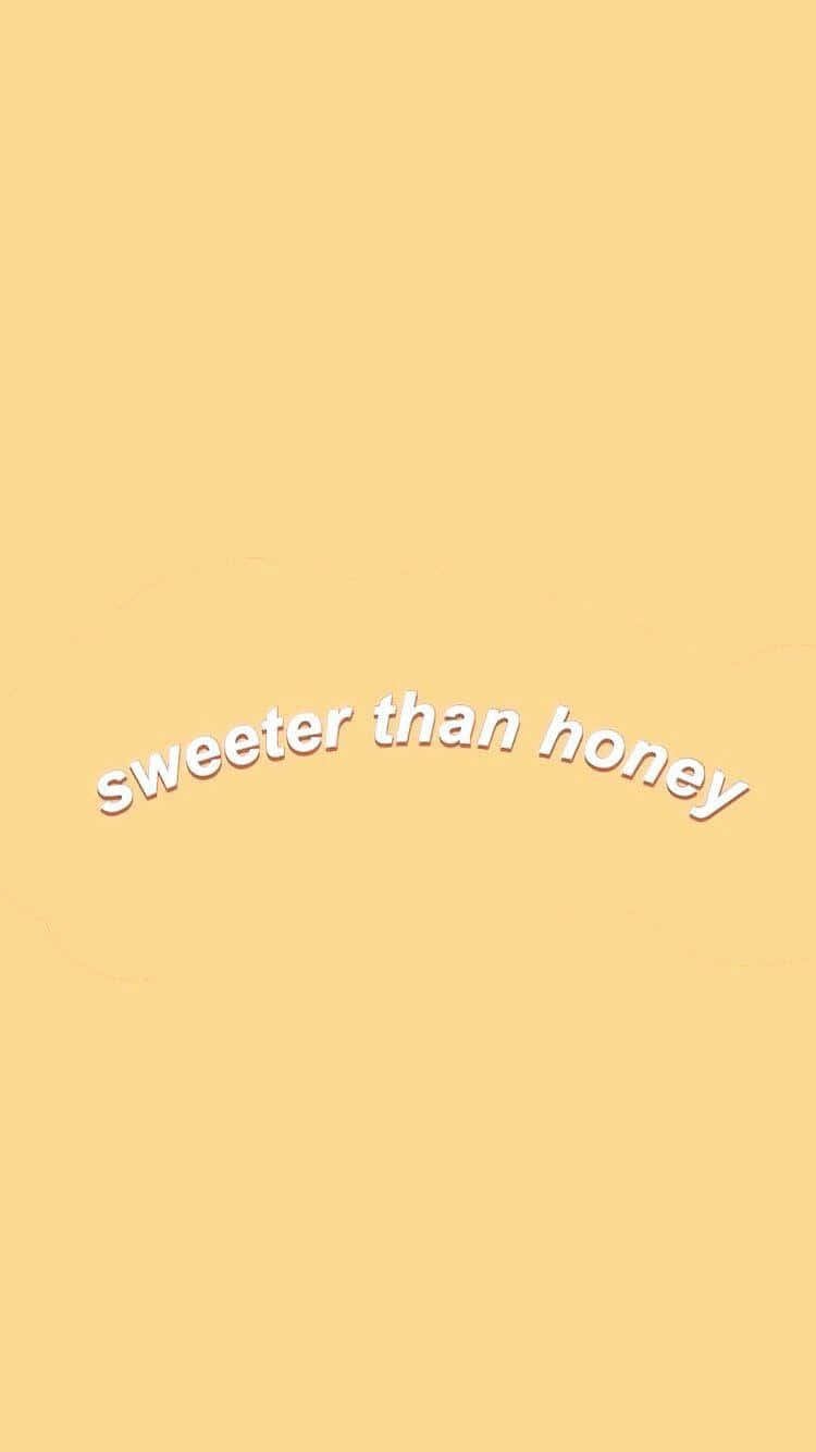 Aesthetic Yellow 桌布 壁紙 — 簡約的淡黃色背景上，以白色彎曲文字顯示「sweeter than honey」字句。