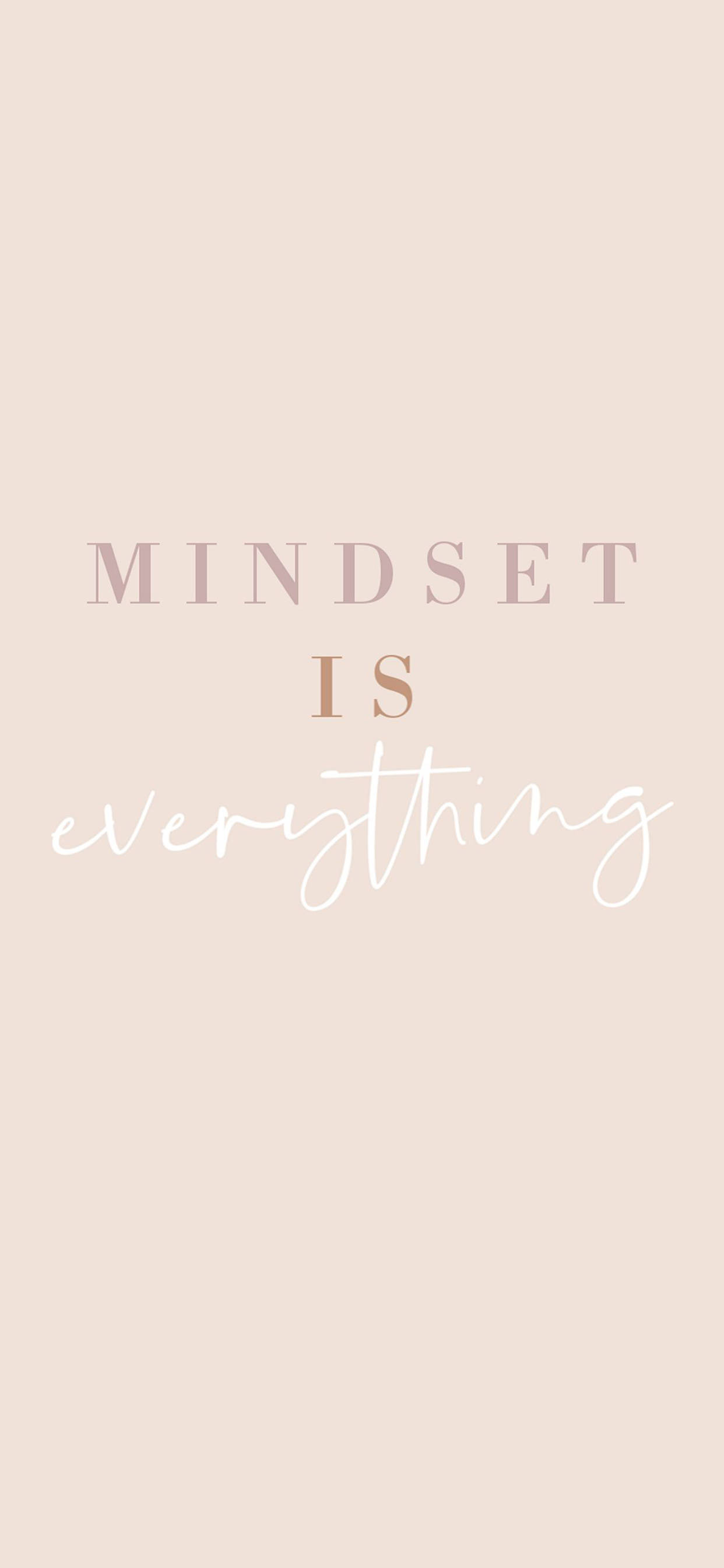 勵志 iPhone 桌布 壁紙 — 簡約粉彩色粉紅色桌布，中央有混合字體的「MINDSET IS everything」字句，置於柔和背景上。