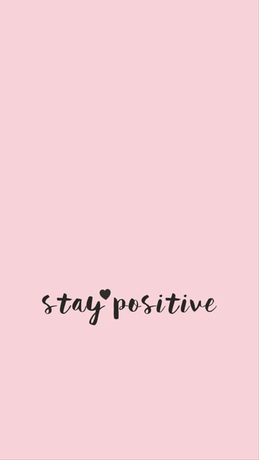 可愛女生 桌布 壁紙 — 簡約粉紅色背景，黑色草書文字寫著 stay positive，並用心形取代 i 上的一點。