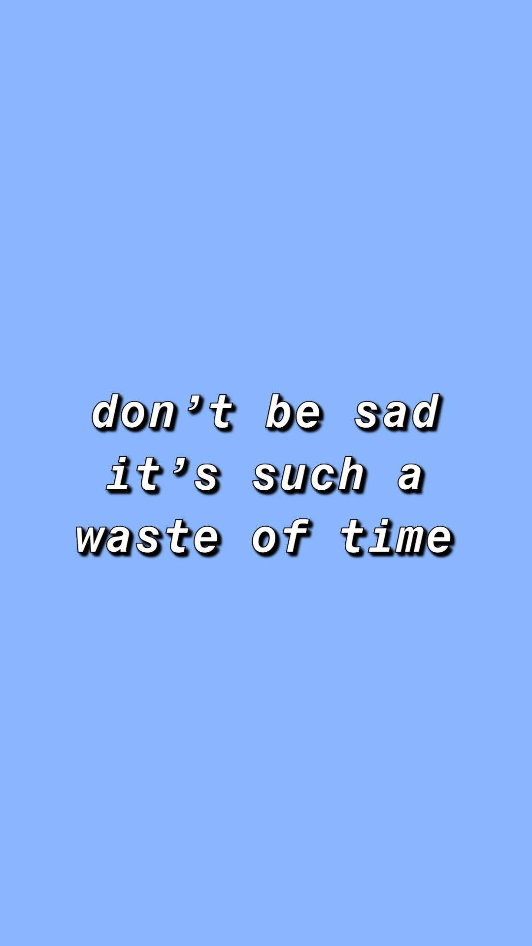 嬰兒藍 桌布 壁紙 — 簡約藍色背景上，以粗體白色字體顯示 don't be sad it's such a waste of time，並帶有黑色陰影。