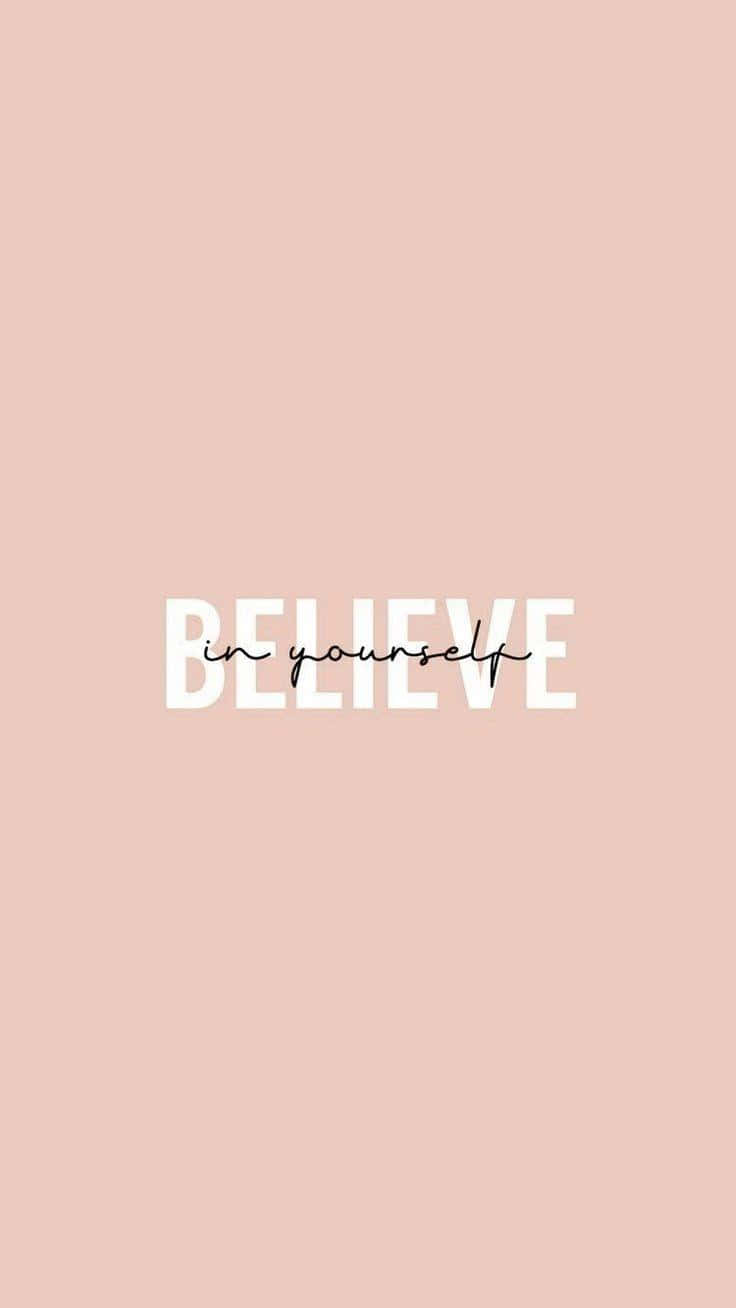 桌布 壁紙 — 簡約蜜桃色背景，中央以粗體白色「BELIEVE」文字和斜體「in yourself」呈現，帶來激勵效果。