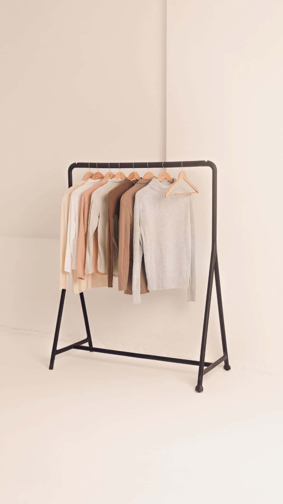 Clothes 桌布 壁紙 — 簡約衣架在潔白的工作室背景前展示柔軟的中性色毛衣。