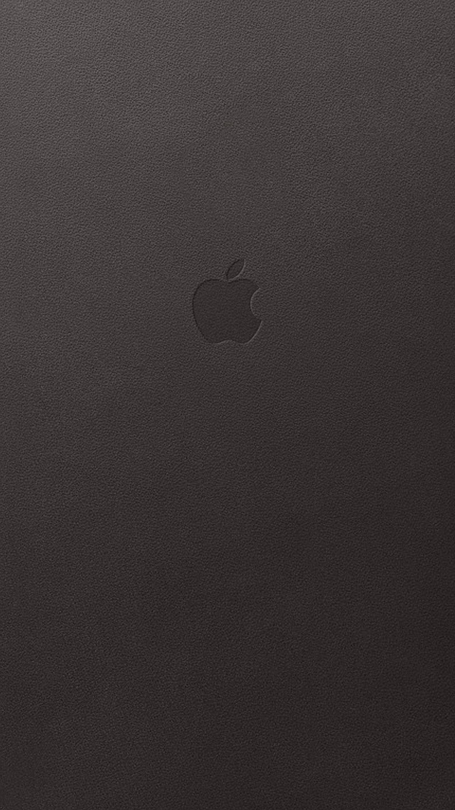 蘋果標誌 桌布 壁紙 — 簡約黑色皮革紋理，中央有微妙的壓印 Apple 標誌。
