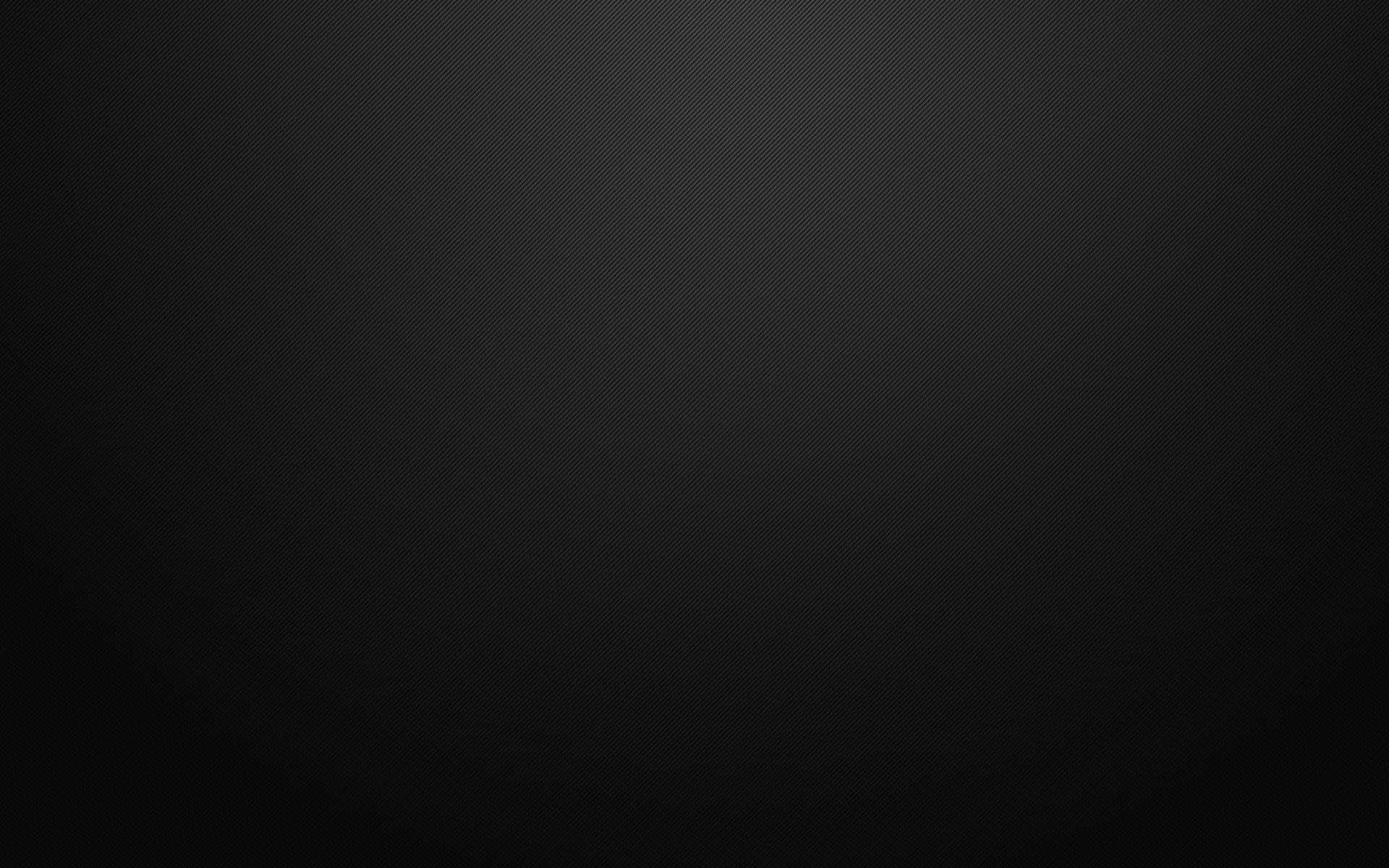 Carbon 桌布 壁紙 — 簡約黑色背景，帶有微妙的對角線紋理和從中心到邊緣的漸變淡出效果。