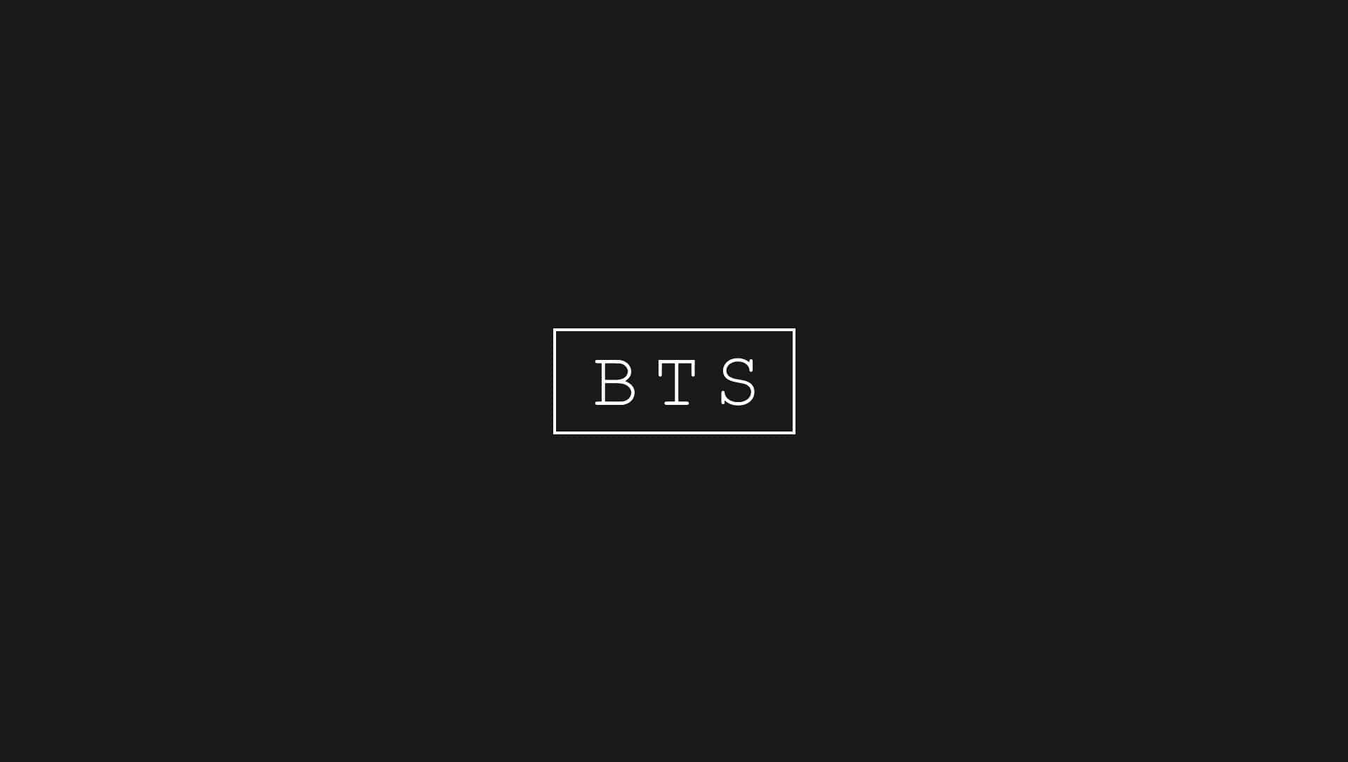 美學筆電 桌布 壁紙 — 簡約黑色背景，白色邊框的「BTS」文字居中，採用乾淨的現代字體。