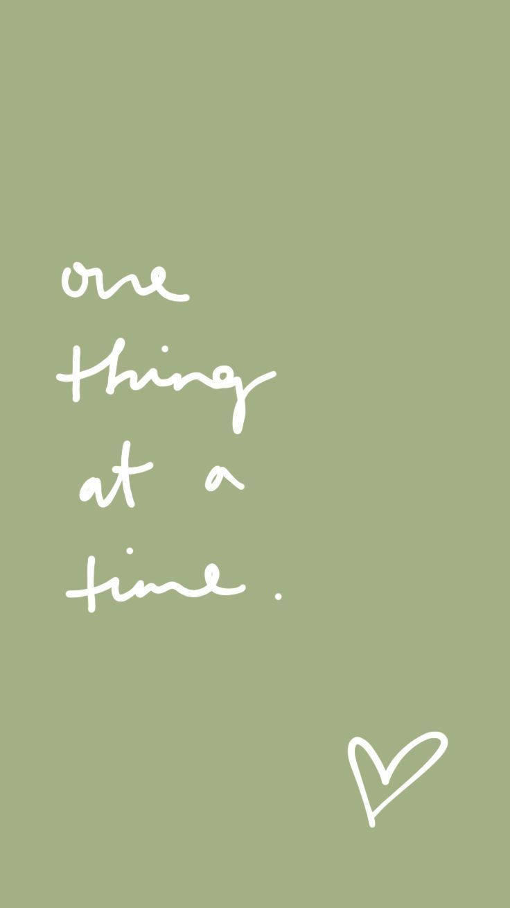 語錄 桌布 壁紙 — 簡約鼠尾草綠色背景，白色手寫文字寫著「one thing at a time」和一個小心形。
