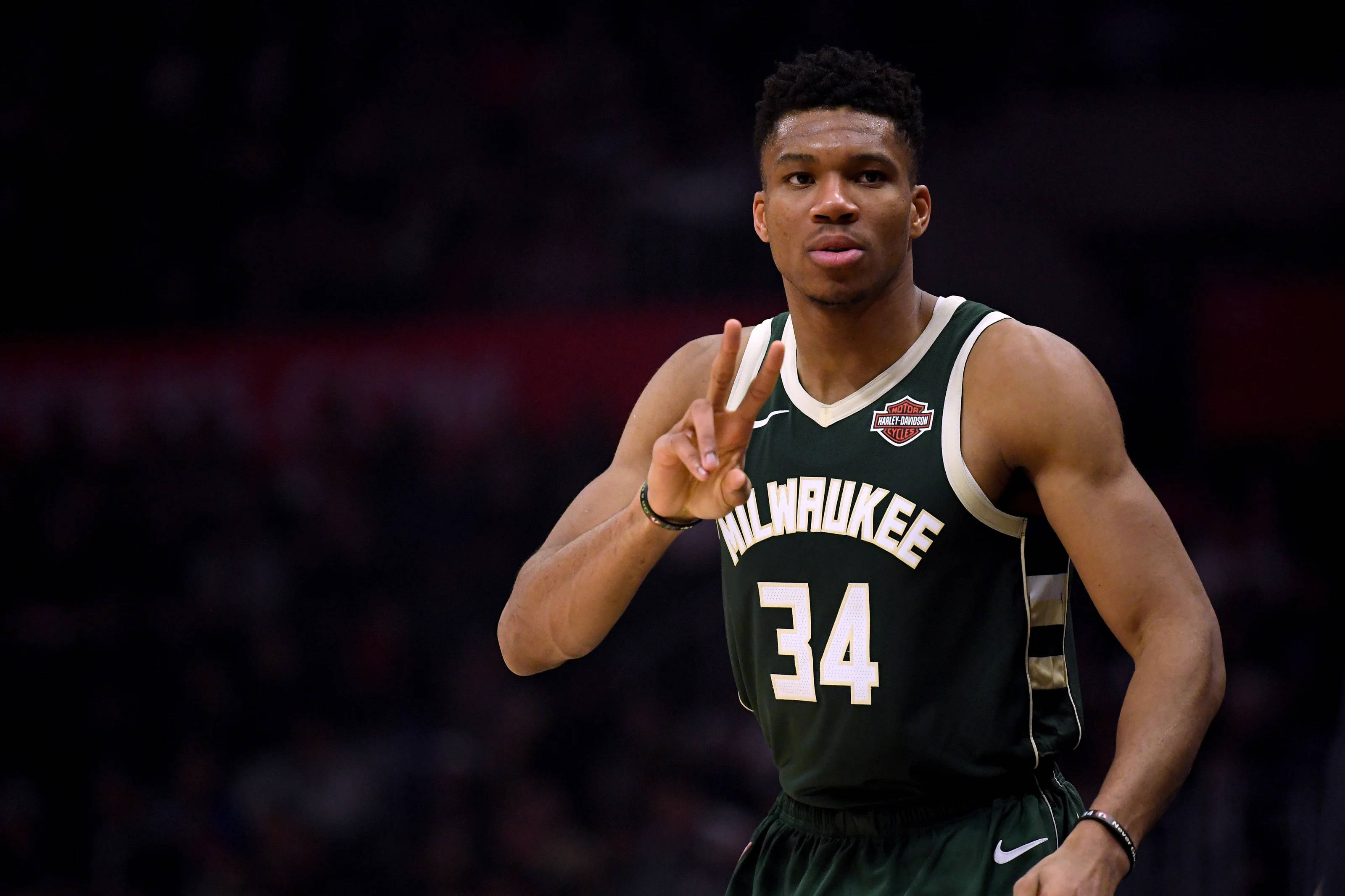 Giannis 桌布 壁紙 — 籃球運動員 Giannis Antetokounmpo 身穿密爾瓦基公鹿隊 34 號球衣，在比賽中做出和平手勢。