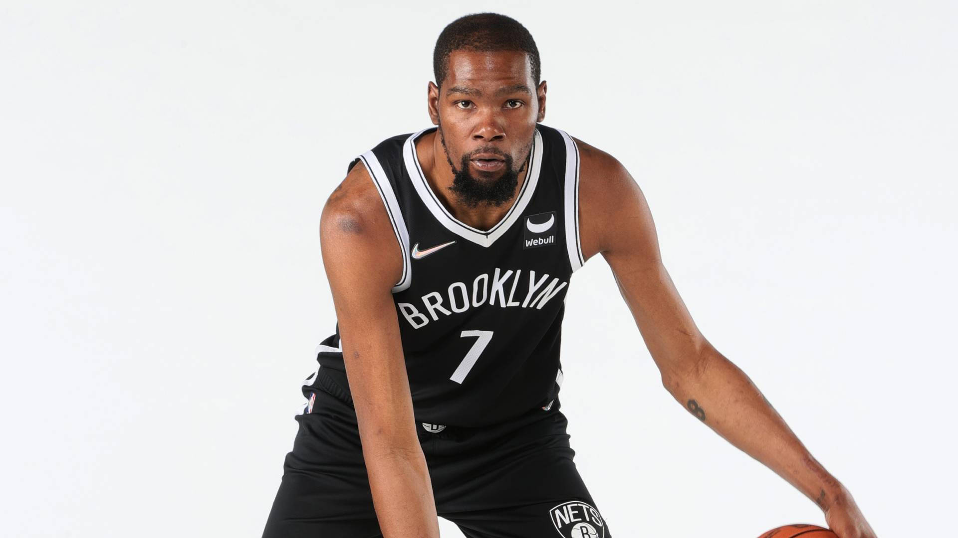 Brooklyn 桌布 壁紙 — 籃球運動員 Kevin Durant 身穿布魯克林籃網隊球衣，在純白色背景下蹲下，專注地拿著籃球。