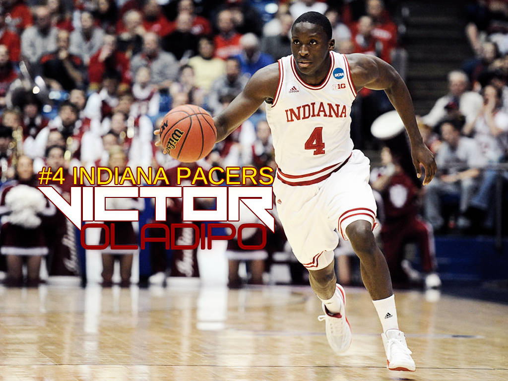 Victor 桌布 壁紙 — 籃球運動員 Victor Oladipo 身穿白色印第安納溜馬隊球衣，在比賽中運球，背景有觀眾。