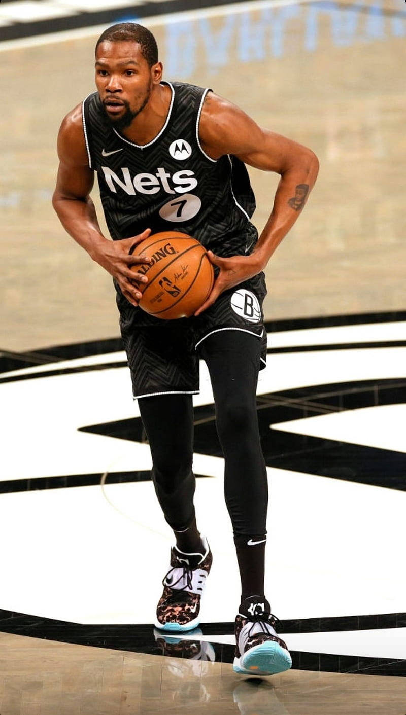 Brooklyn Nets 桌布 壁紙 — 籃球運動員Kevin Durant身穿黑色Nets球衣，在拋光球場上運球，球場地板設計大膽黑白分明。