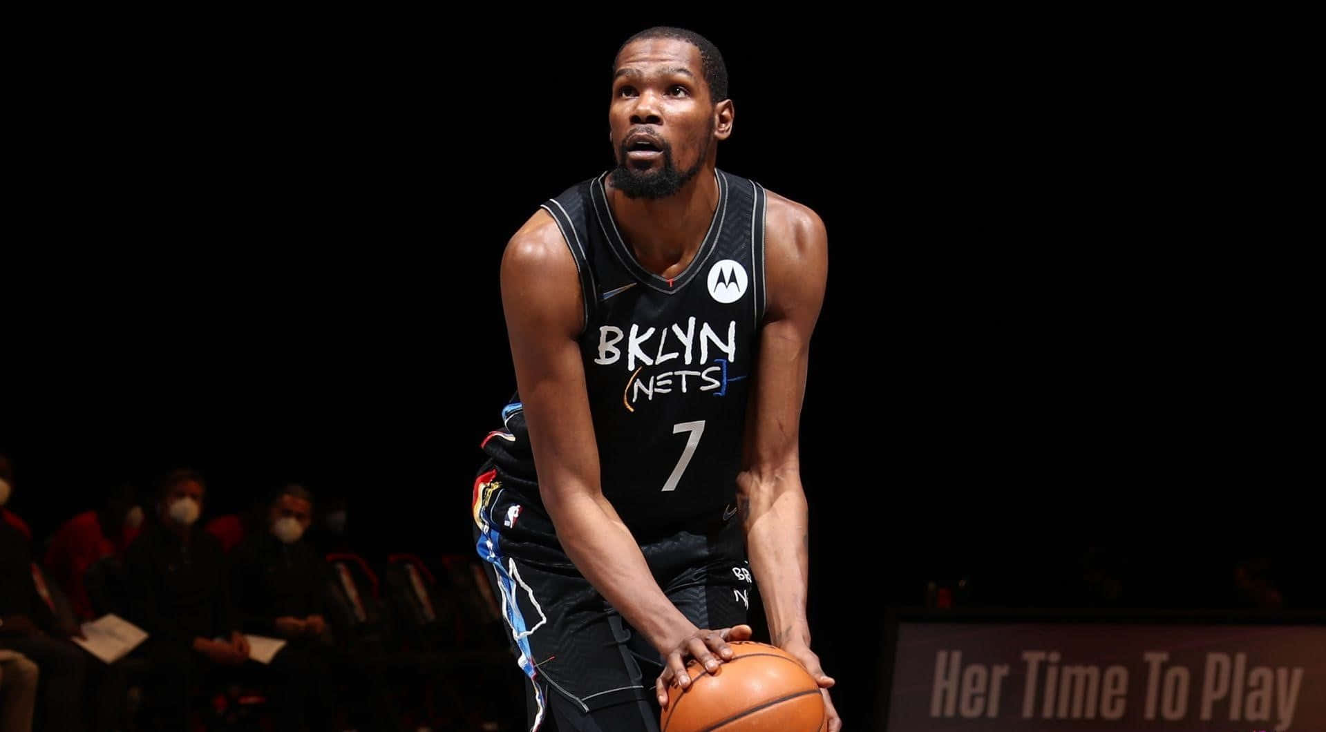 桌布 壁紙 — 籃球運動員Kevin Durant身穿布魯克林籃網隊球衣，在場館燈光下蹲下持球。