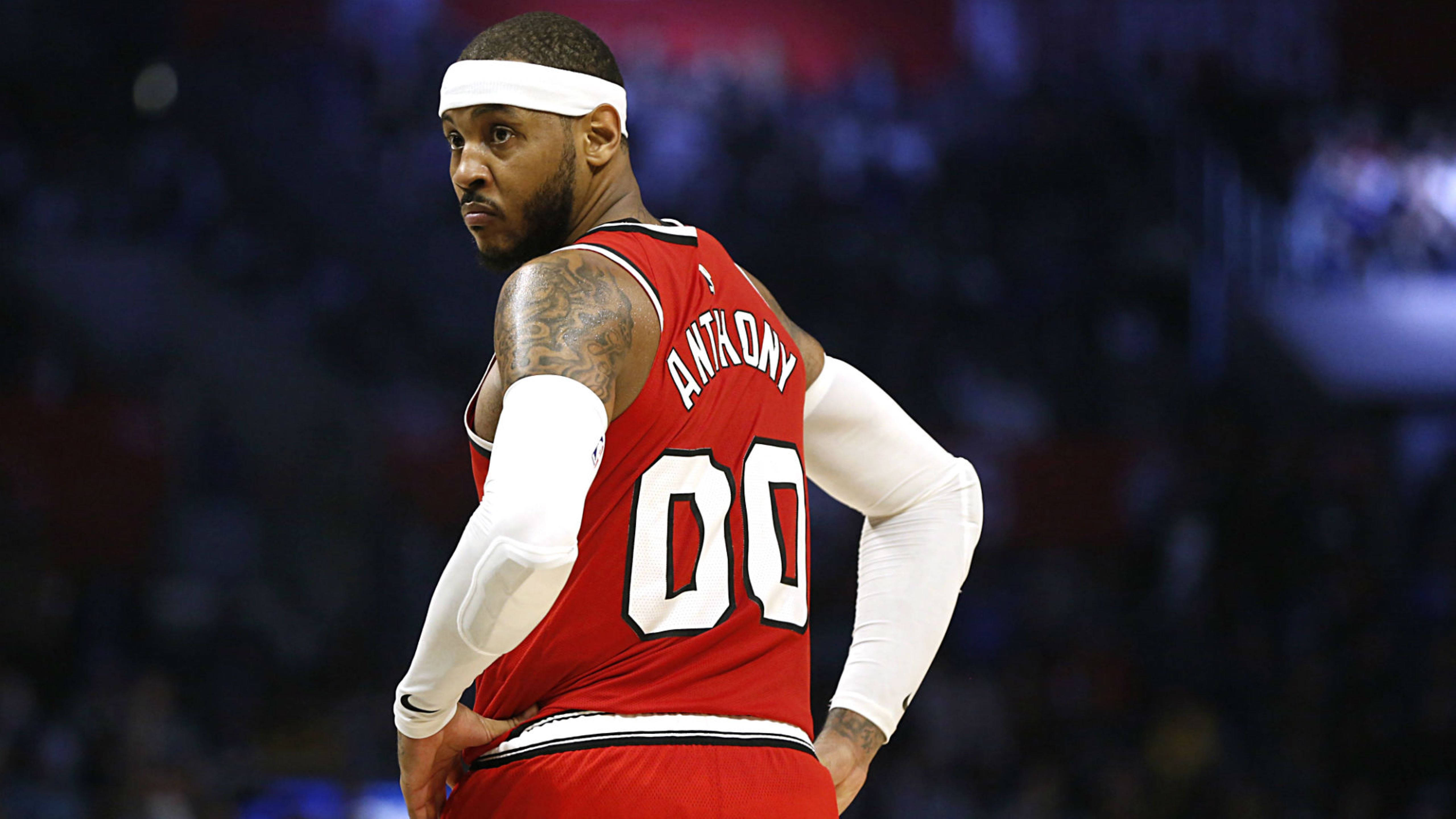 Carmelo 桌布 壁紙 — 籃球運動員卡梅隆·安東尼身穿紅色球衣，號碼00，在比賽中雙手叉腰站在場館燈光下。