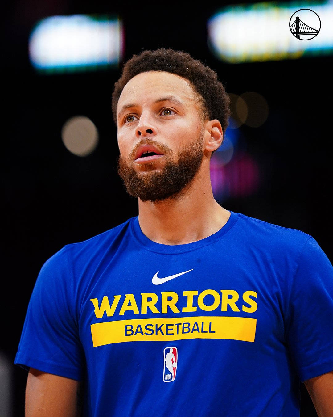 NBA 桌布 壁紙 — 籃球運動員史蒂芬柯瑞身穿藍色勇士隊球衣的特寫，身後是模糊的場館燈光。