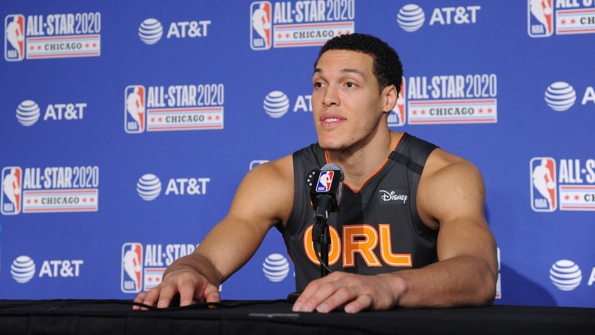 aaron gordon 桌布 壁紙 — 籃球運動員在記者會上發言，身穿奧蘭多魔術隊球衣，背景為藍色NBA全明星2020。
