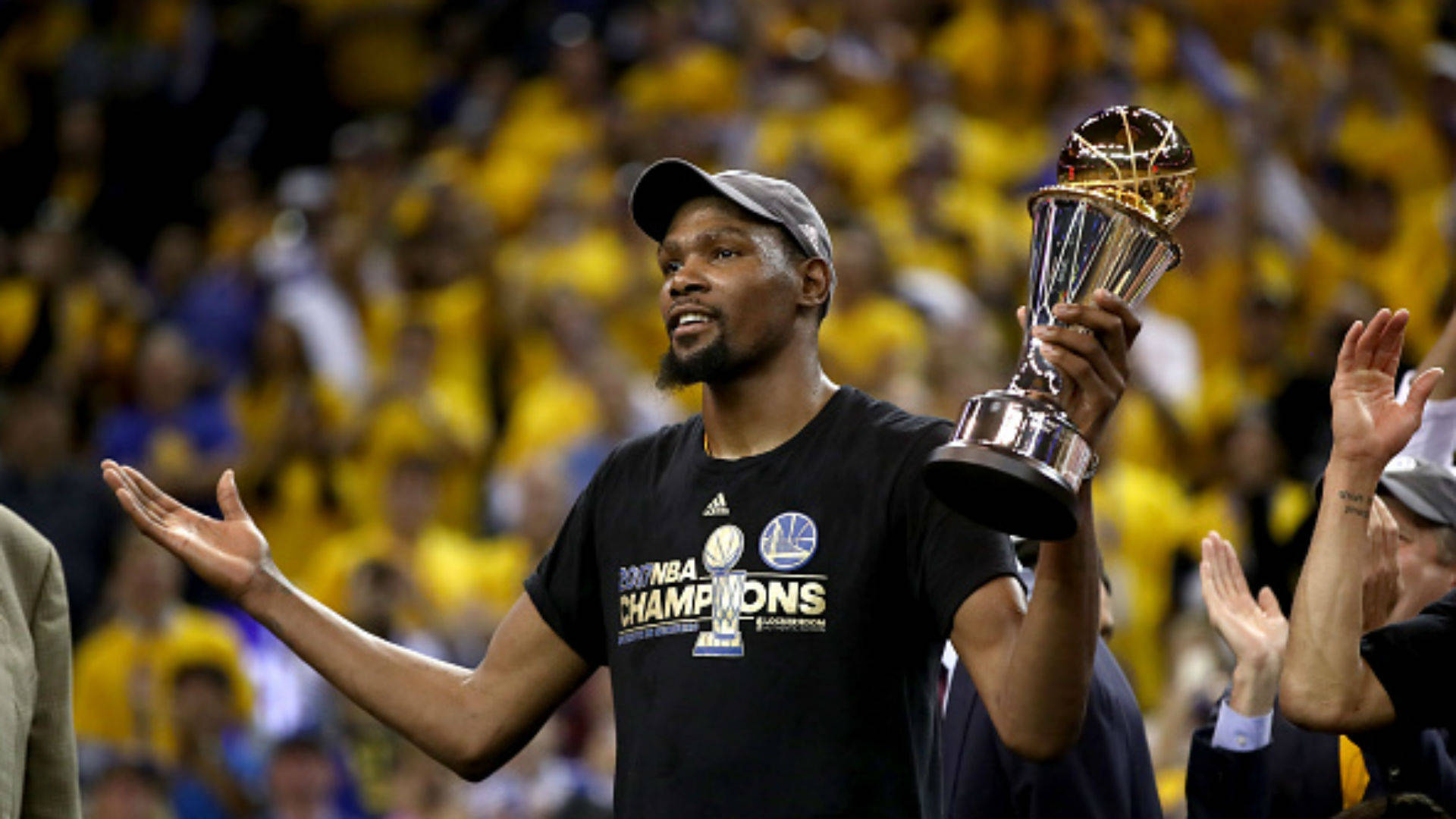 finals 桌布 壁紙 — 籃球運動員在身穿黃色衣服的喧鬧人群面前高舉NBA冠軍獎盃。