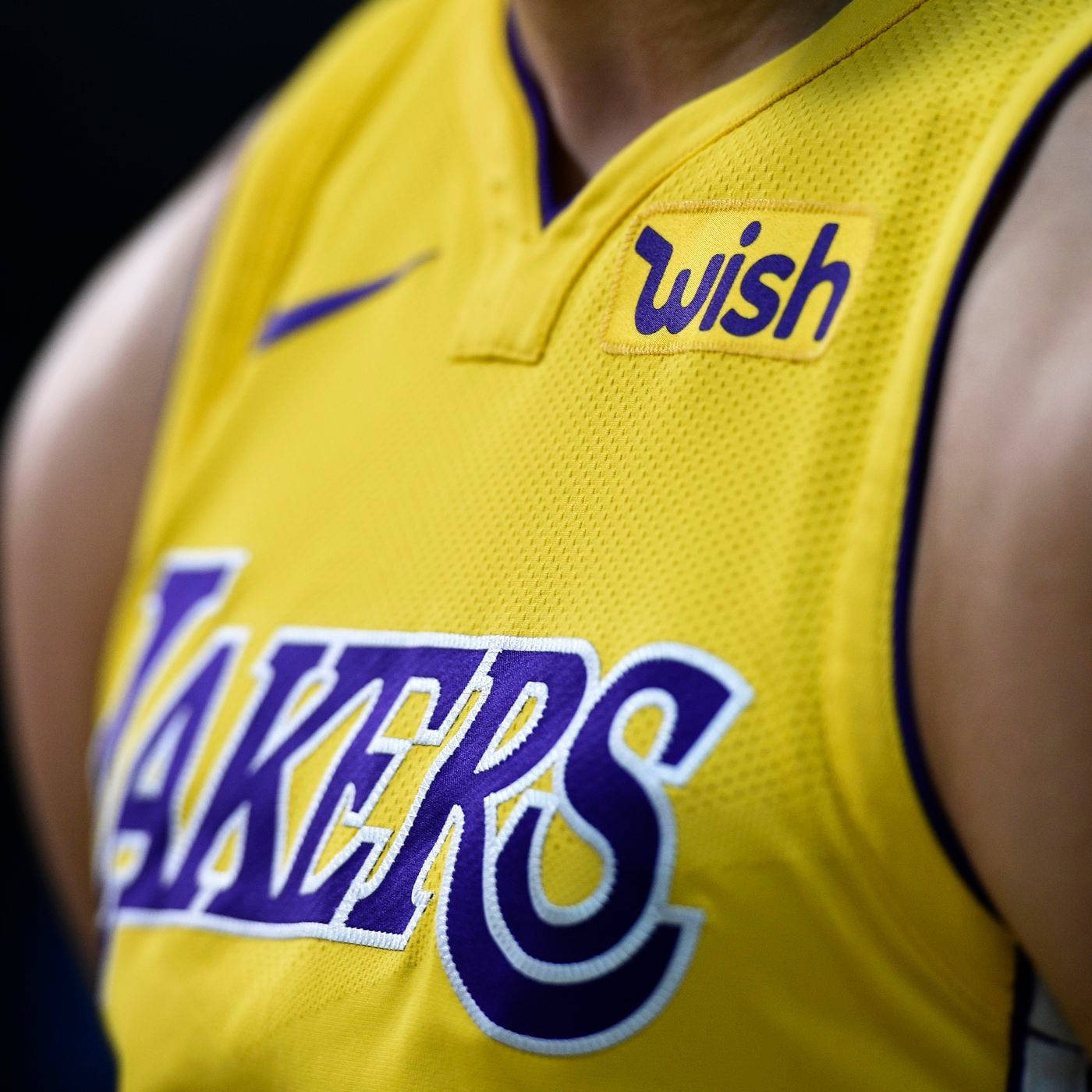 NBA 桌布 壁紙 — 籃球運動員黃色湖人隊球衣的特寫，帶有紫色和白色字體以及Wish贊助商標誌。