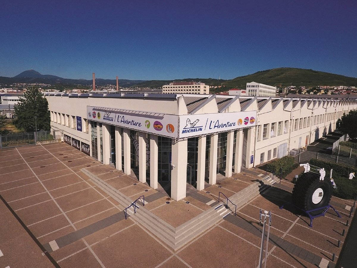 Museum 桌布 壁紙 — 米其林冒險博物館的空中景觀，巨型輪胎雕塑在清澈藍天下。