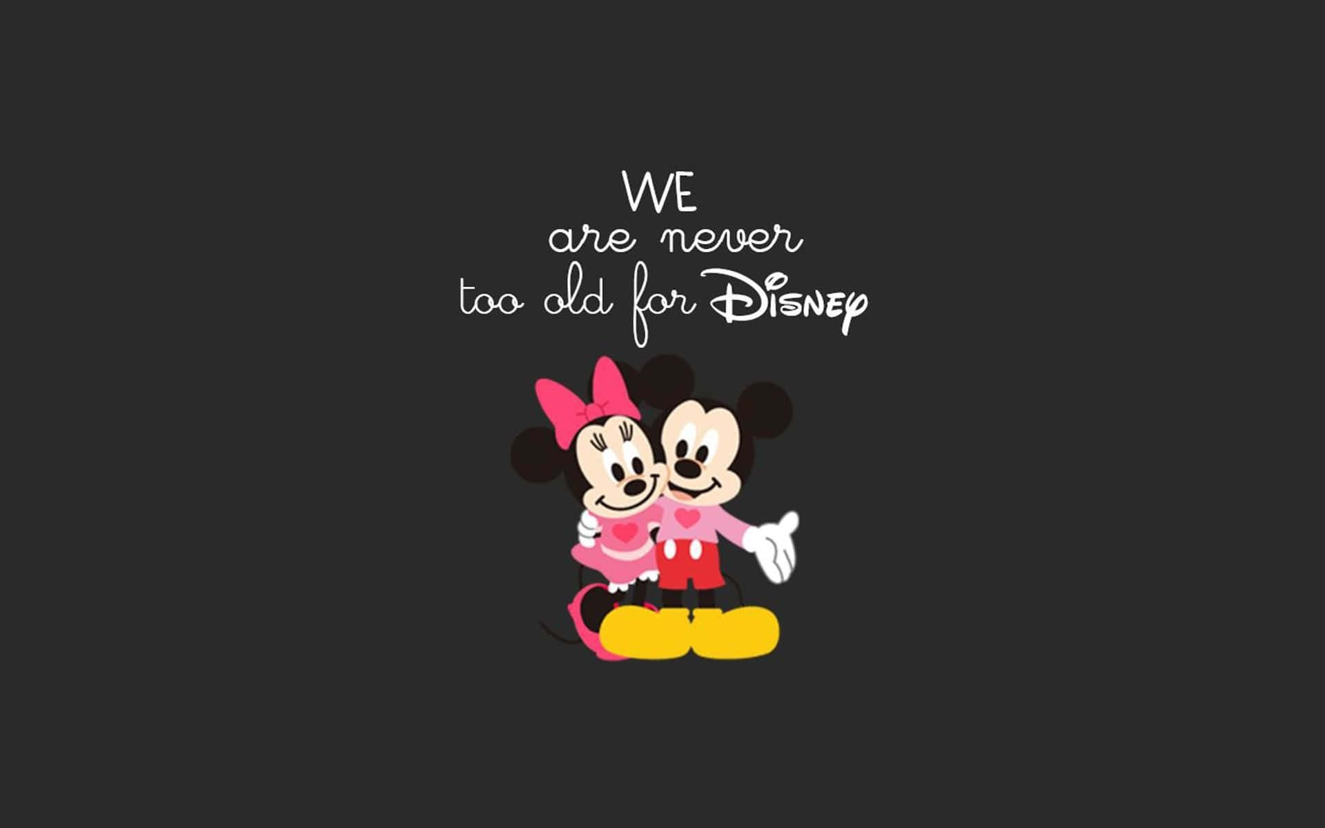Mickey And Minnie Mouse 桌布 壁紙 — 米奇和米妮老鼠在深灰色背景前溫暖擁抱，並有白色字體寫著「We are never too old for Disney」。